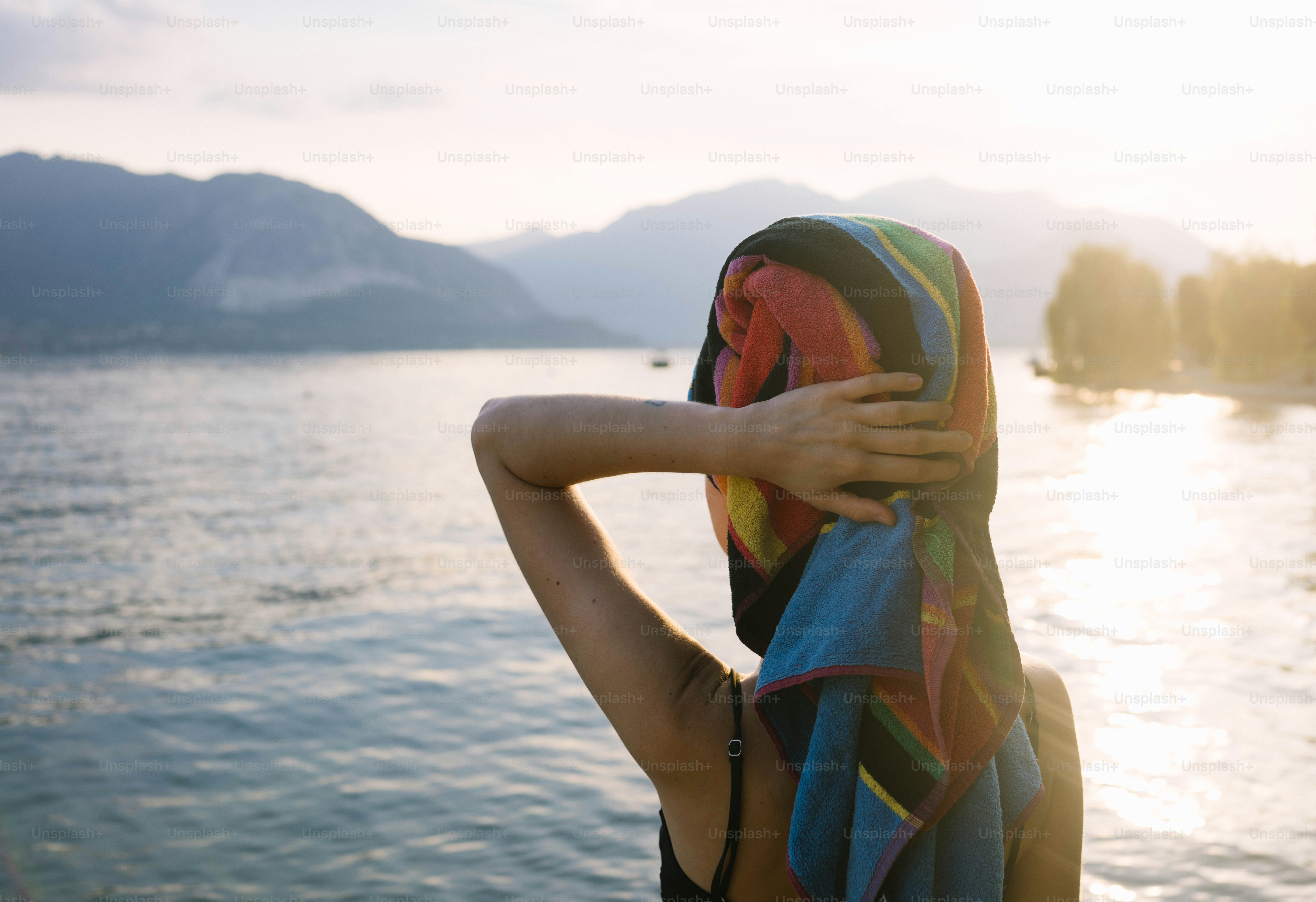 A woman standing on a boat looking out at the water photo – Beach Image ...