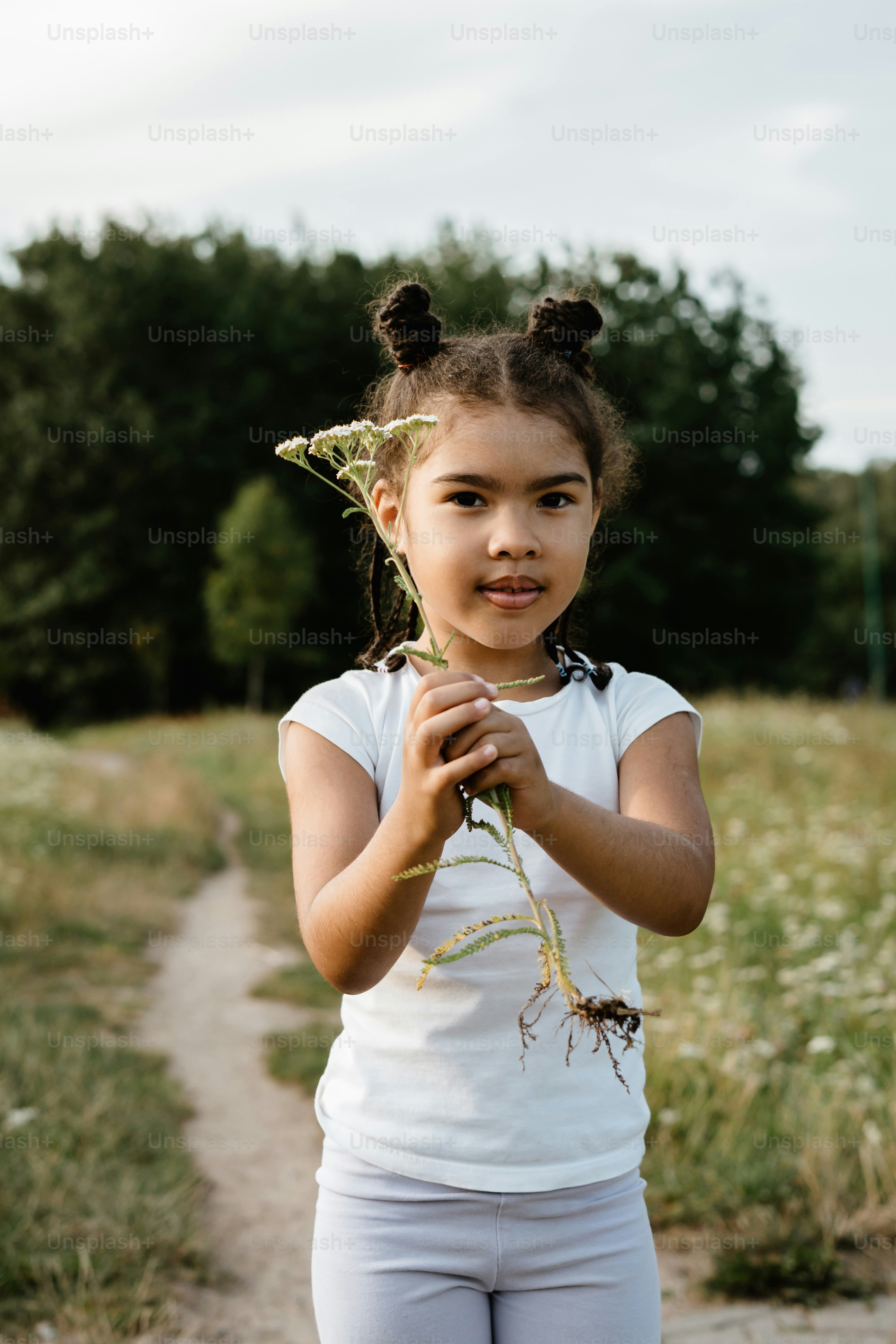 A young girl holding a plant in her hands