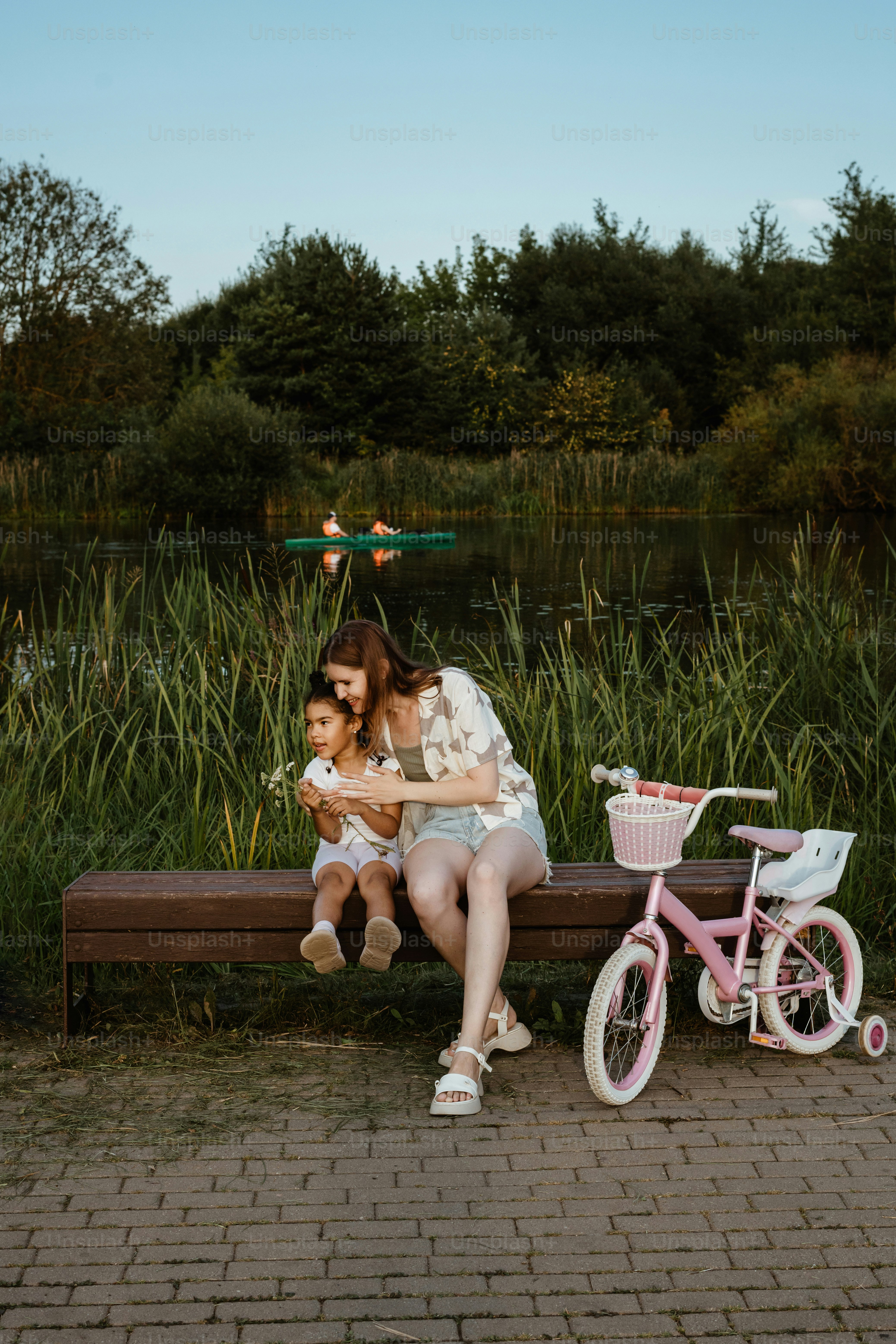 A woman sitting on a bench next to a little girl