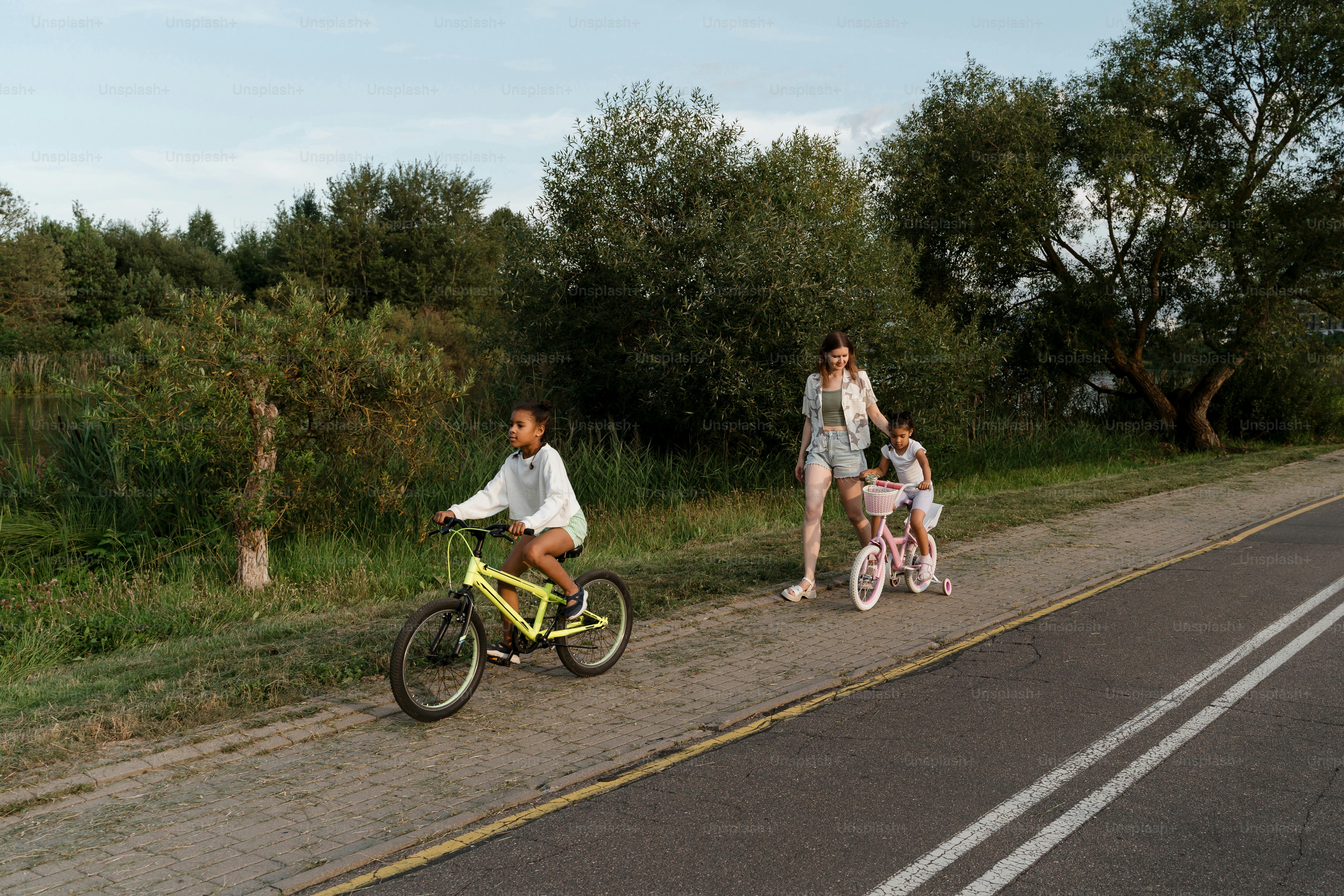 A family of three riding bikes down a road