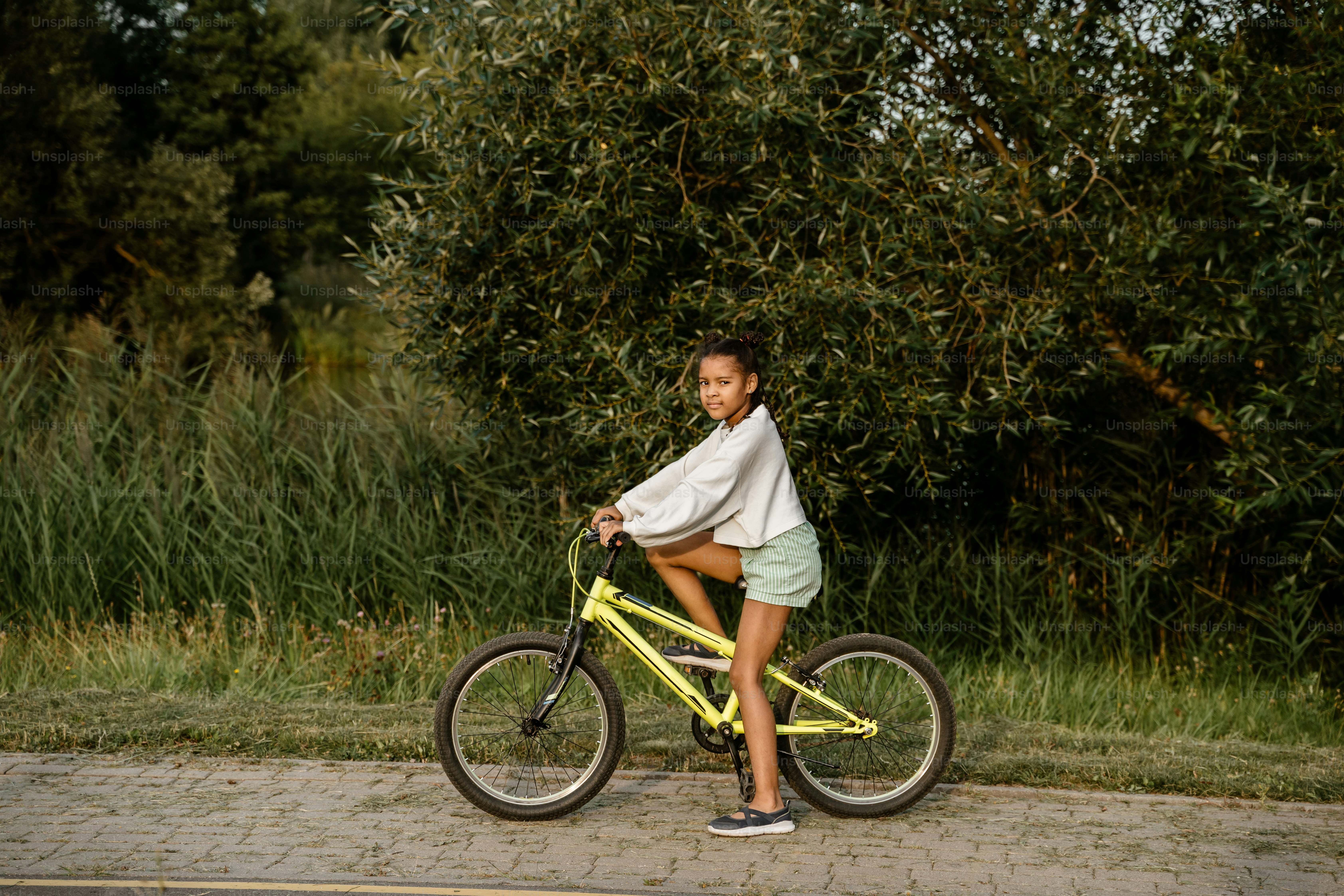 A woman riding a yellow bike down a street