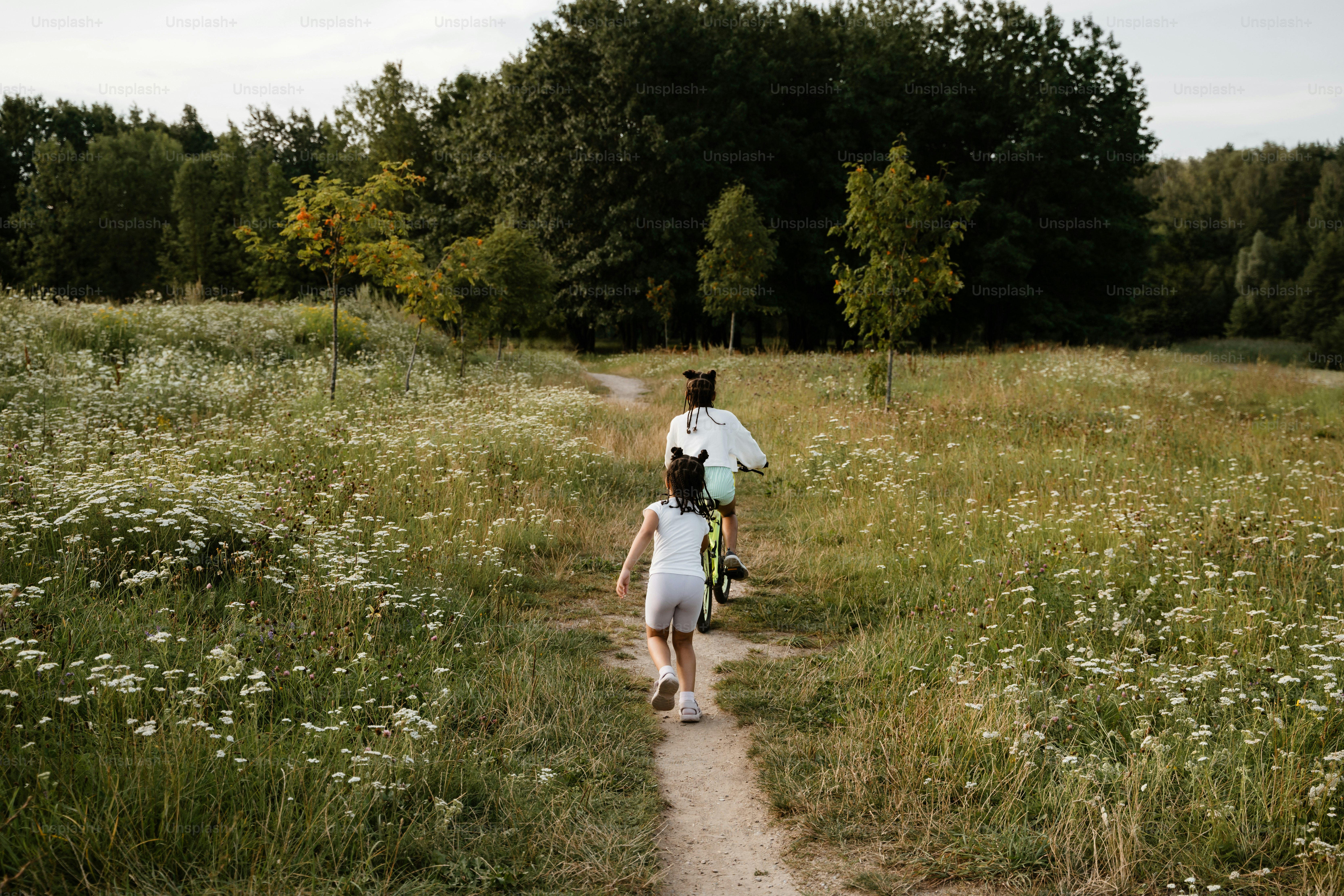 A man and a little girl walking down a dirt road