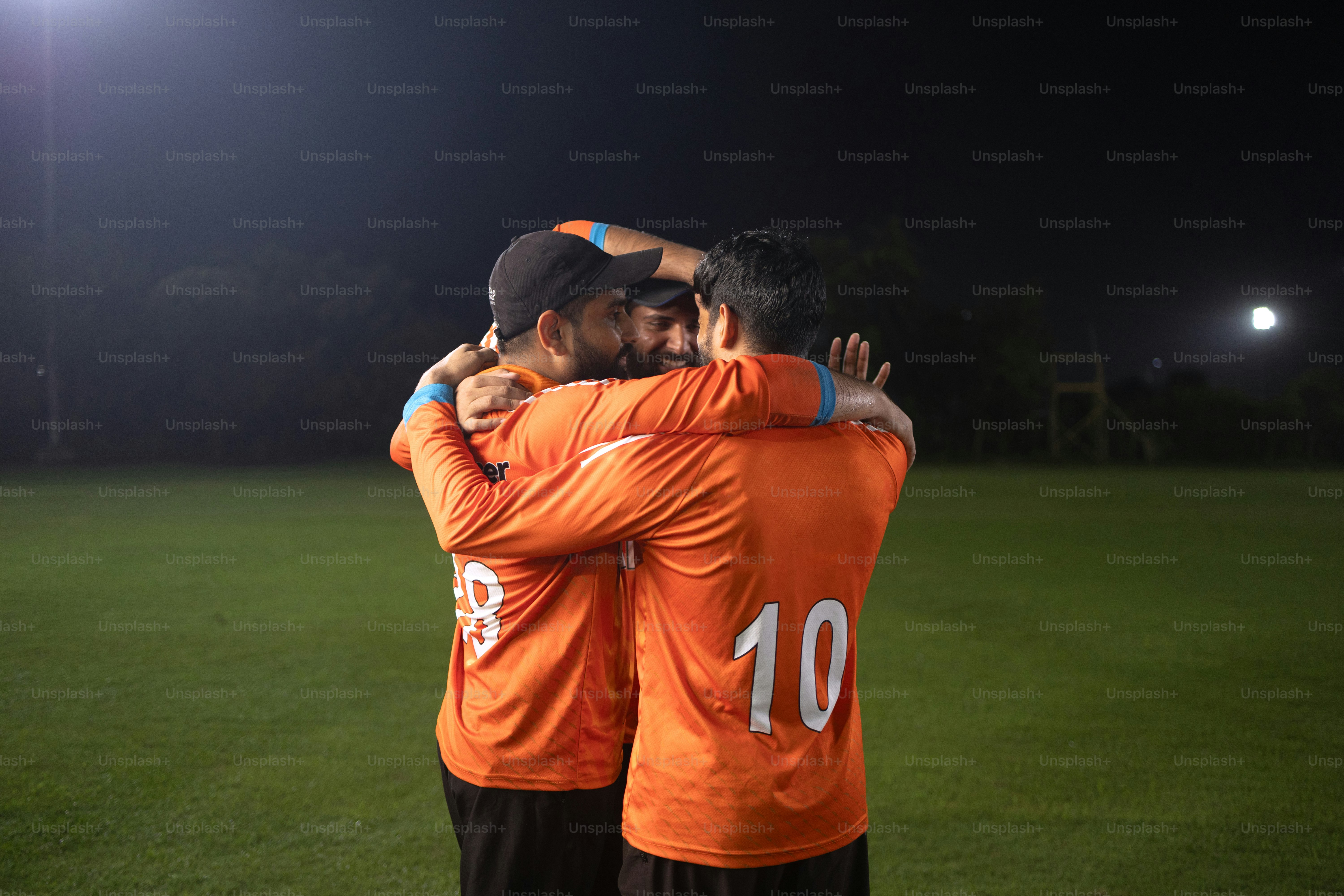 A couple of men standing on top of a soccer field