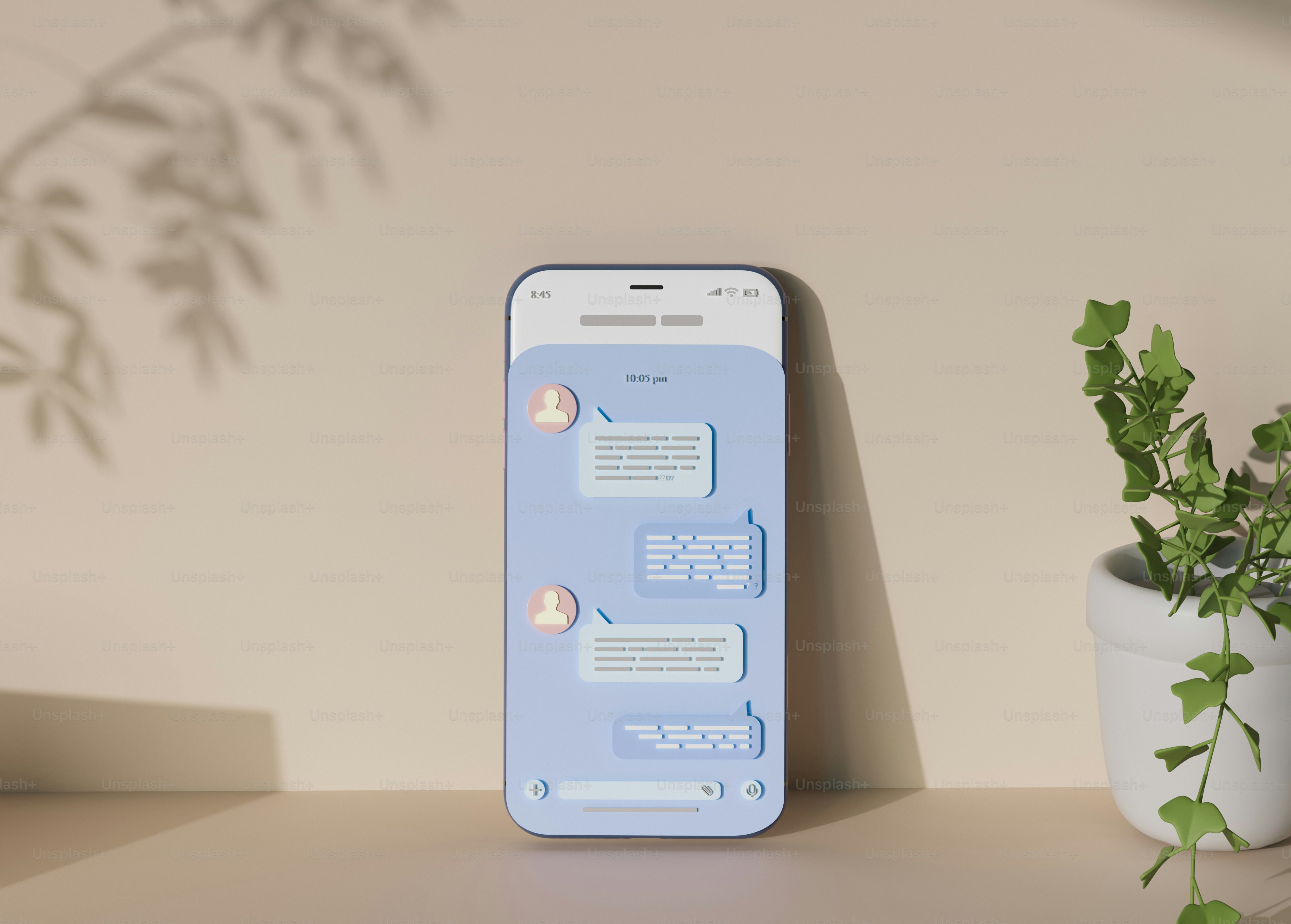 Un teléfono celular encima de una mesa junto a una planta en maceta