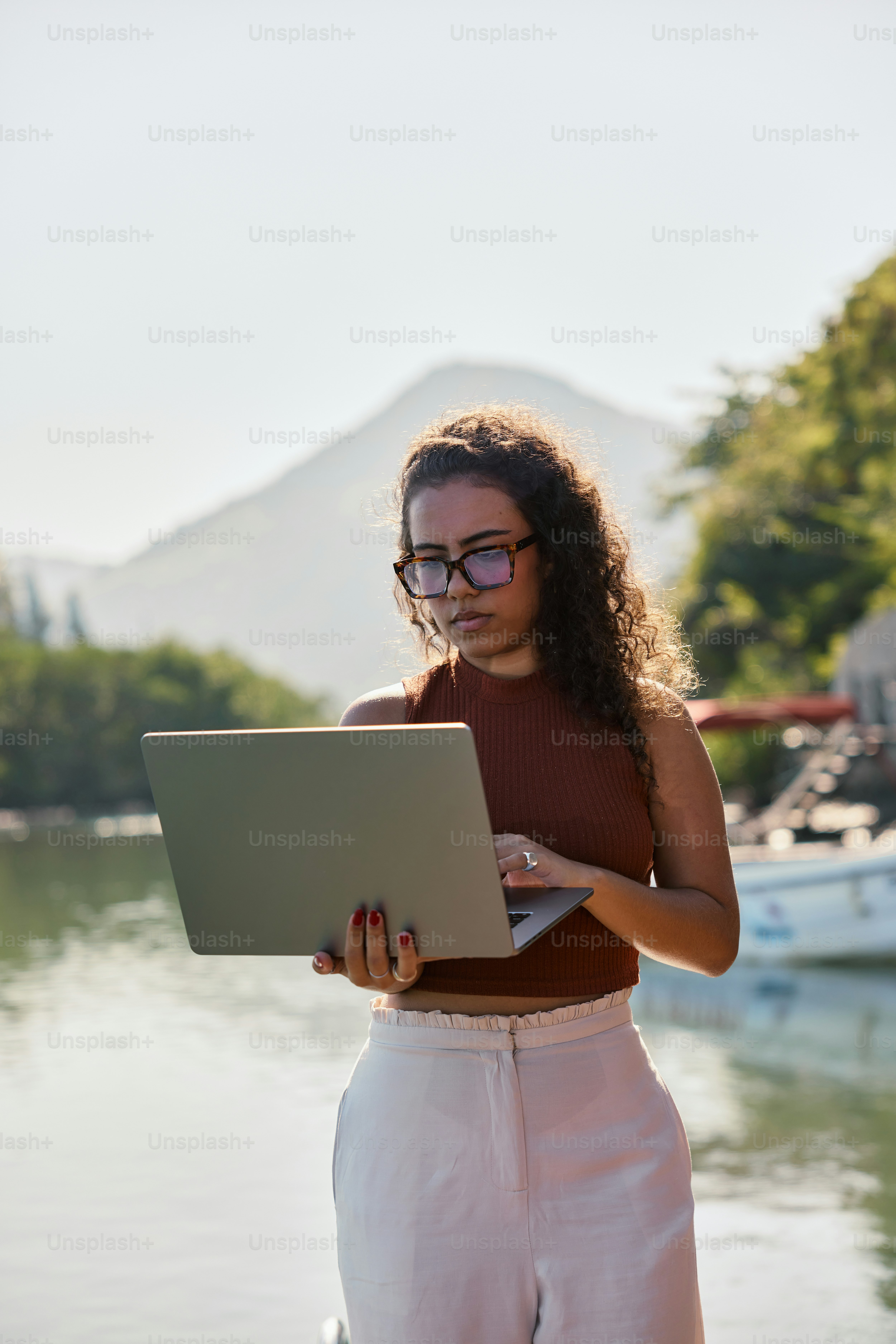 Una mujer de pie en un muelle usando una computadora portátil