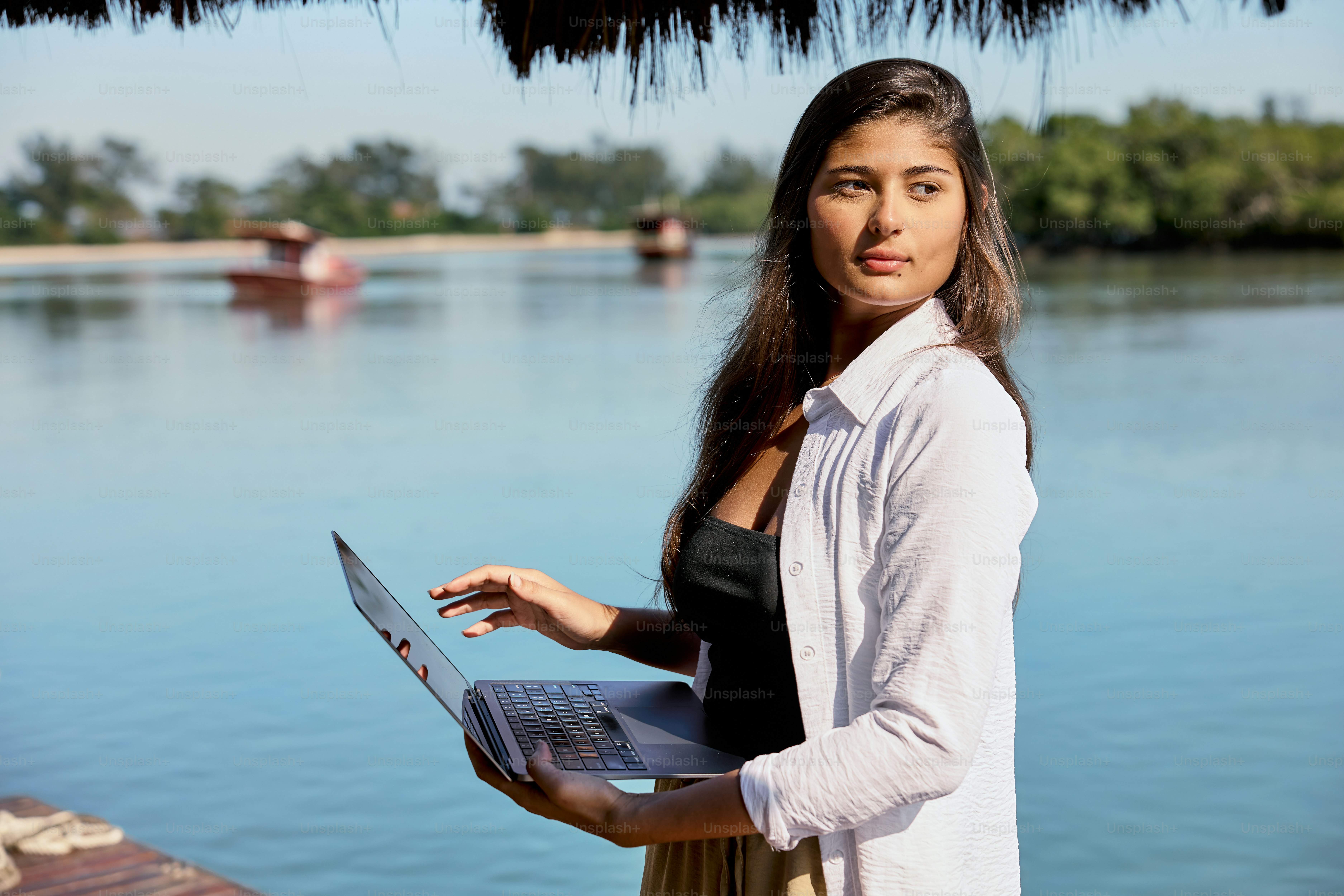 Una mujer de pie en un muelle con una computadora portátil