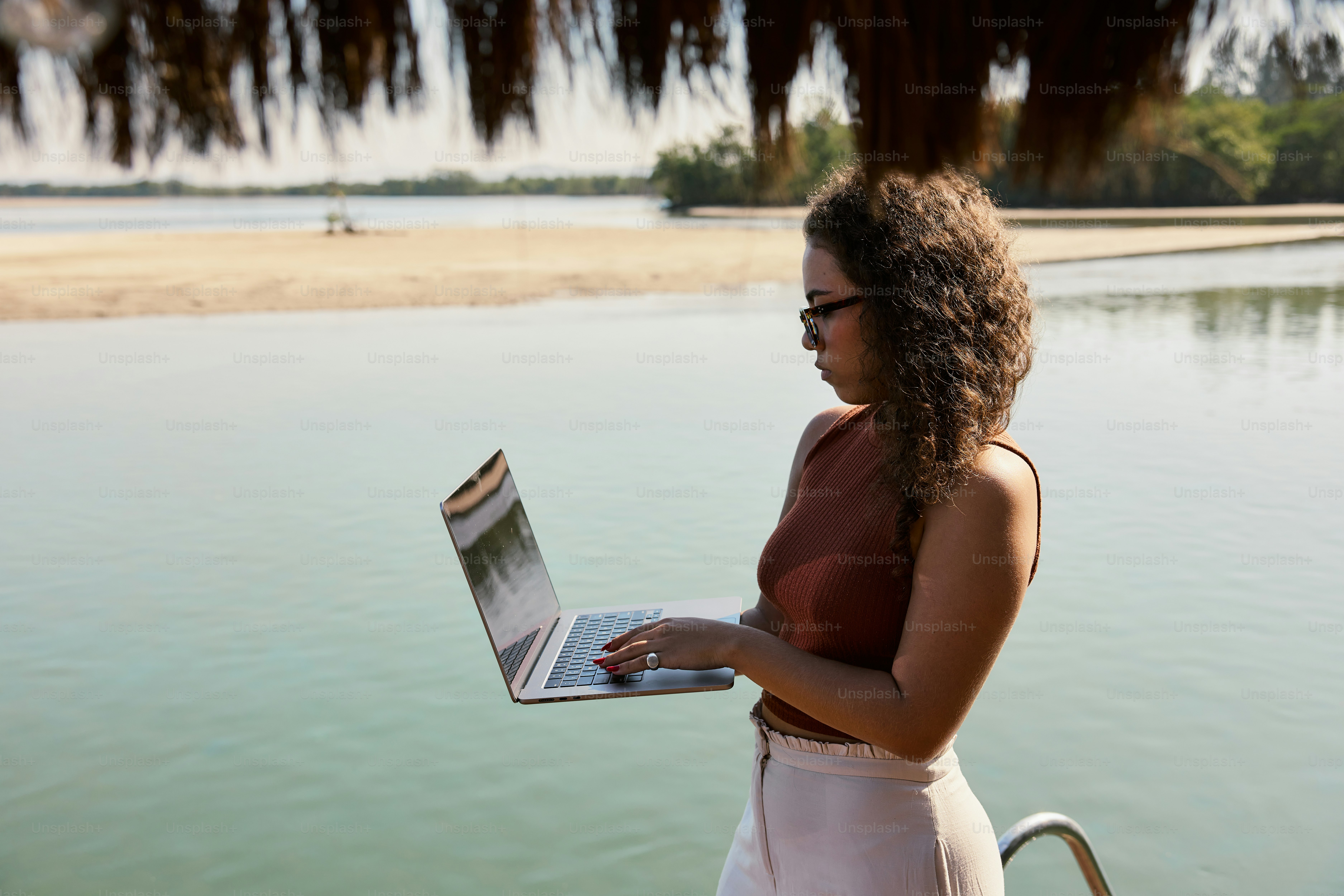 Una mujer con un vestido blanco está usando una computadora portátil