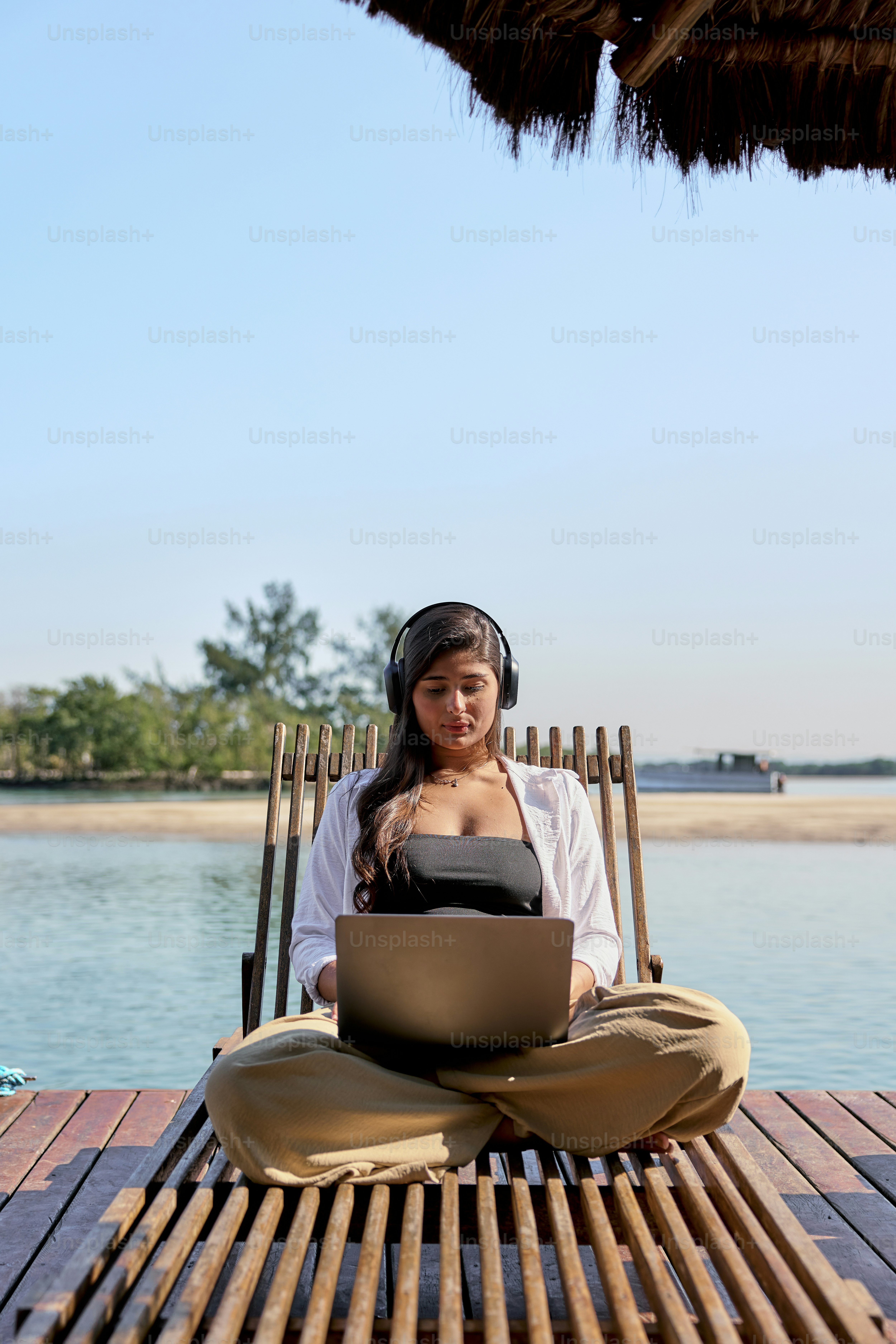 Una mujer sentada en una silla con una computadora portátil en su regazo