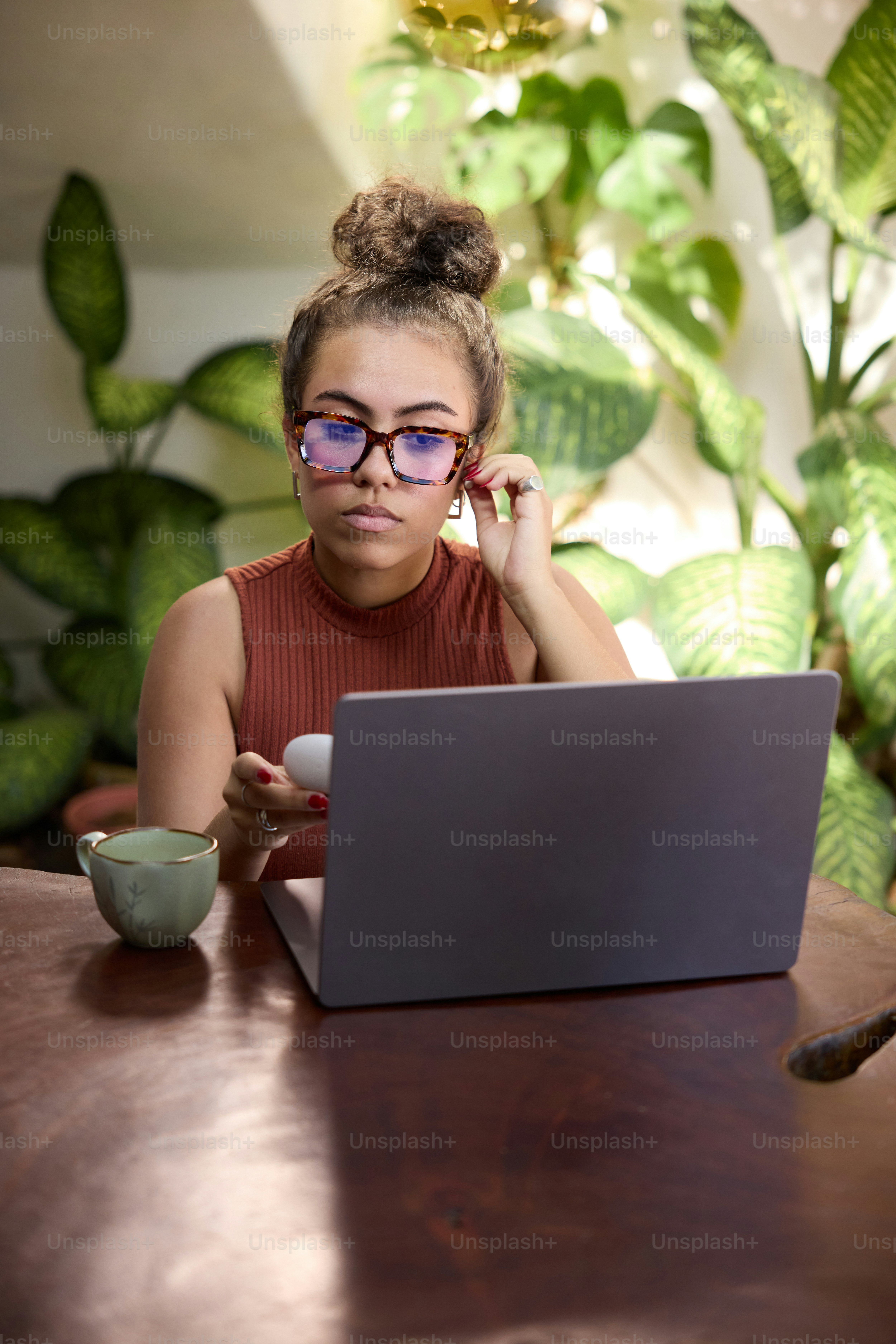 A woman sitting at a table using a laptop computer