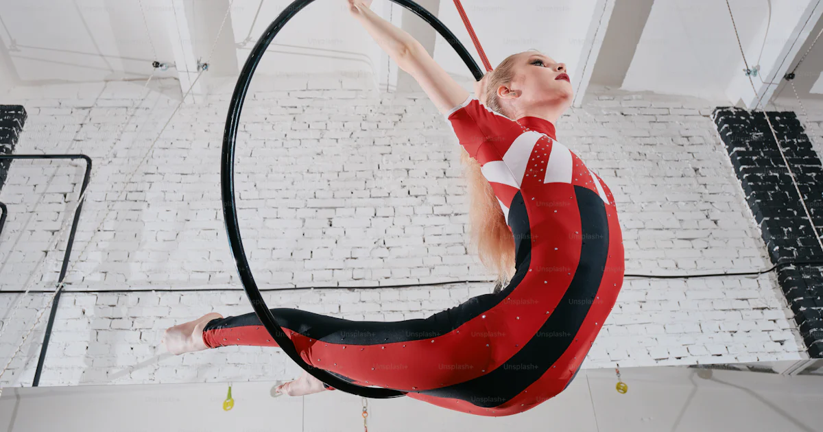 Acrobat Deep A woman in a red and black outfit doing aerial acrobatics photo ...