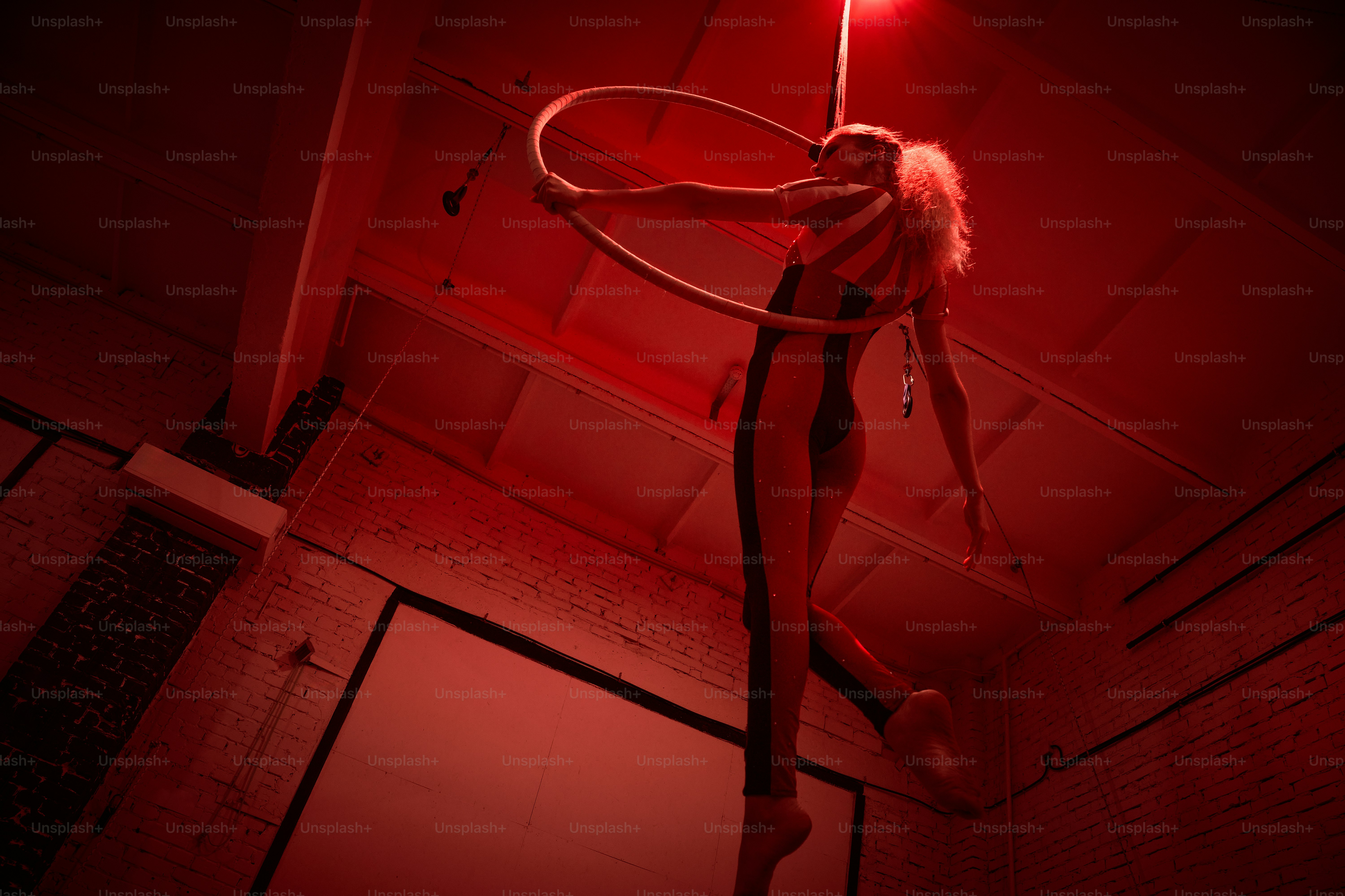 A woman in a dark room with a hula hoop