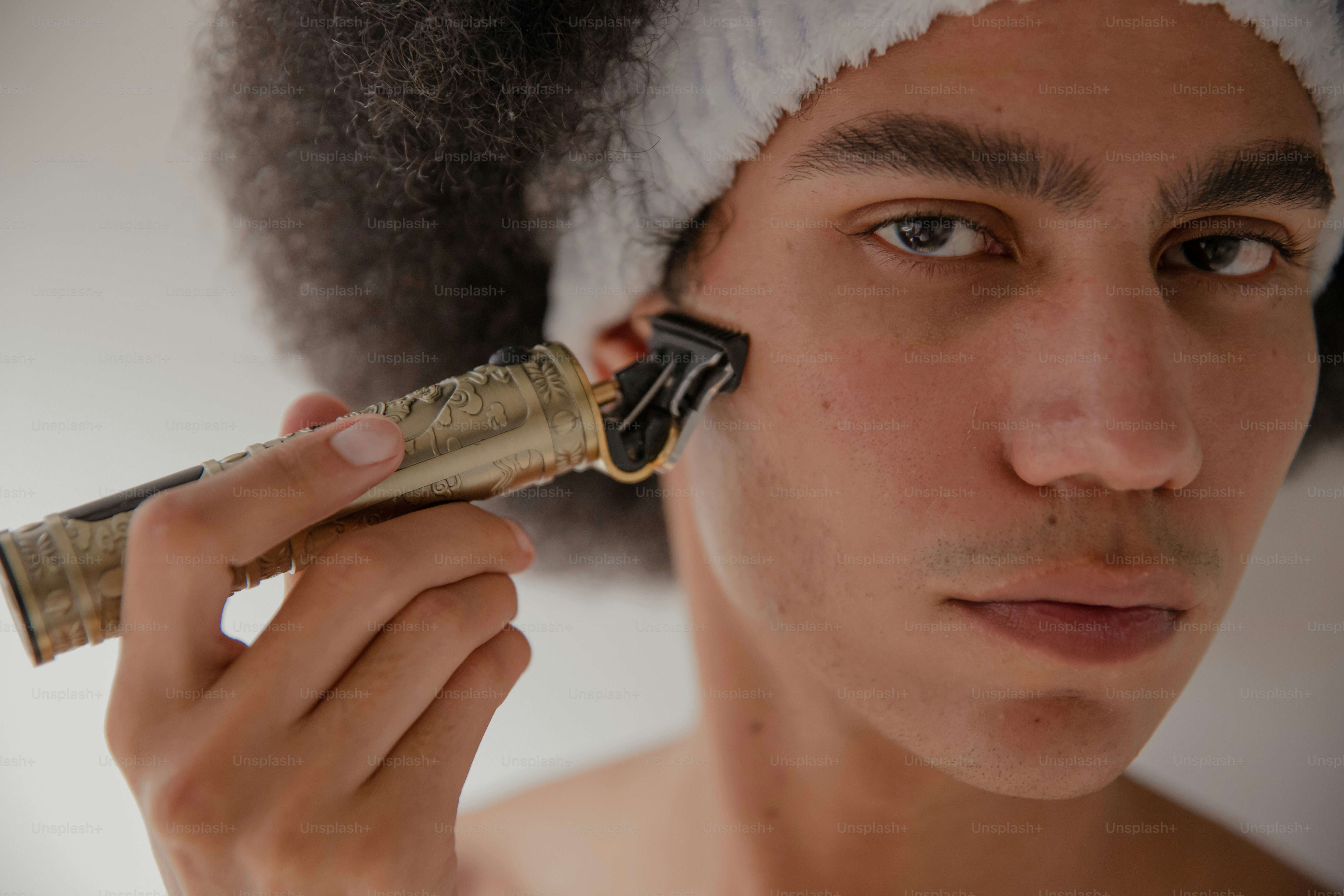 A young man is brushing his hair with an electric brush