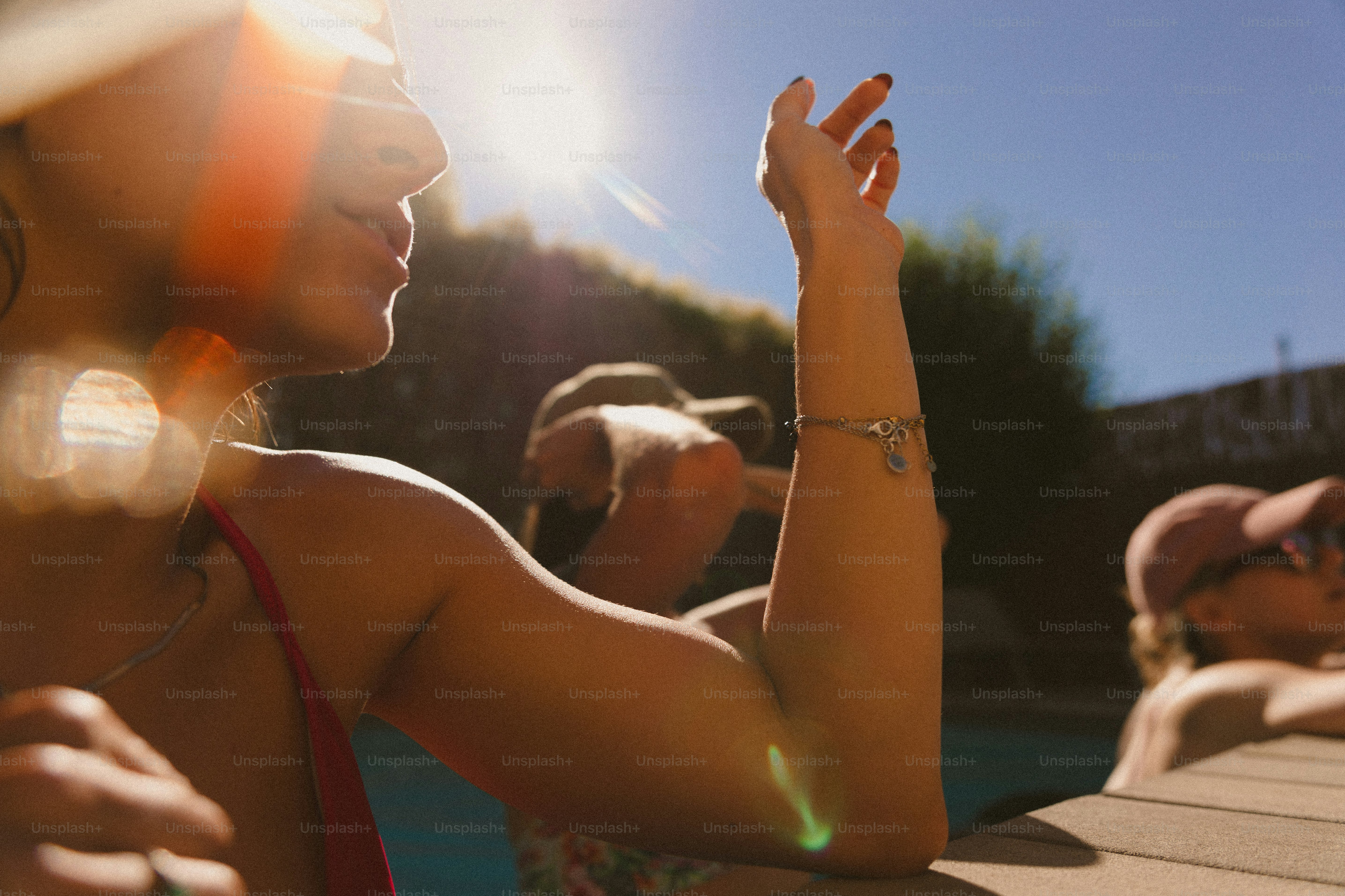 A group of people sitting around a swimming pool
