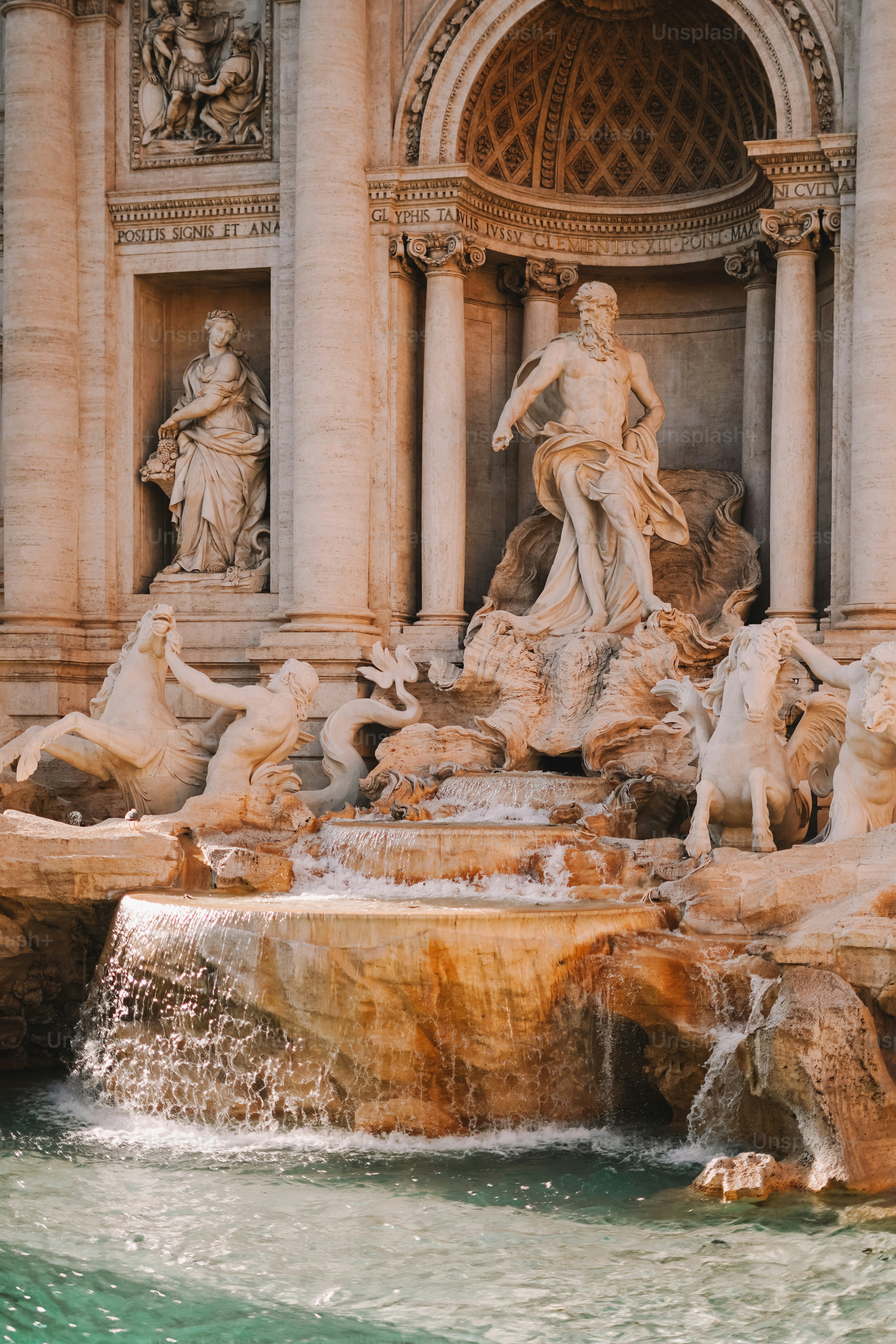 A fountain with statues and water in front of a building
