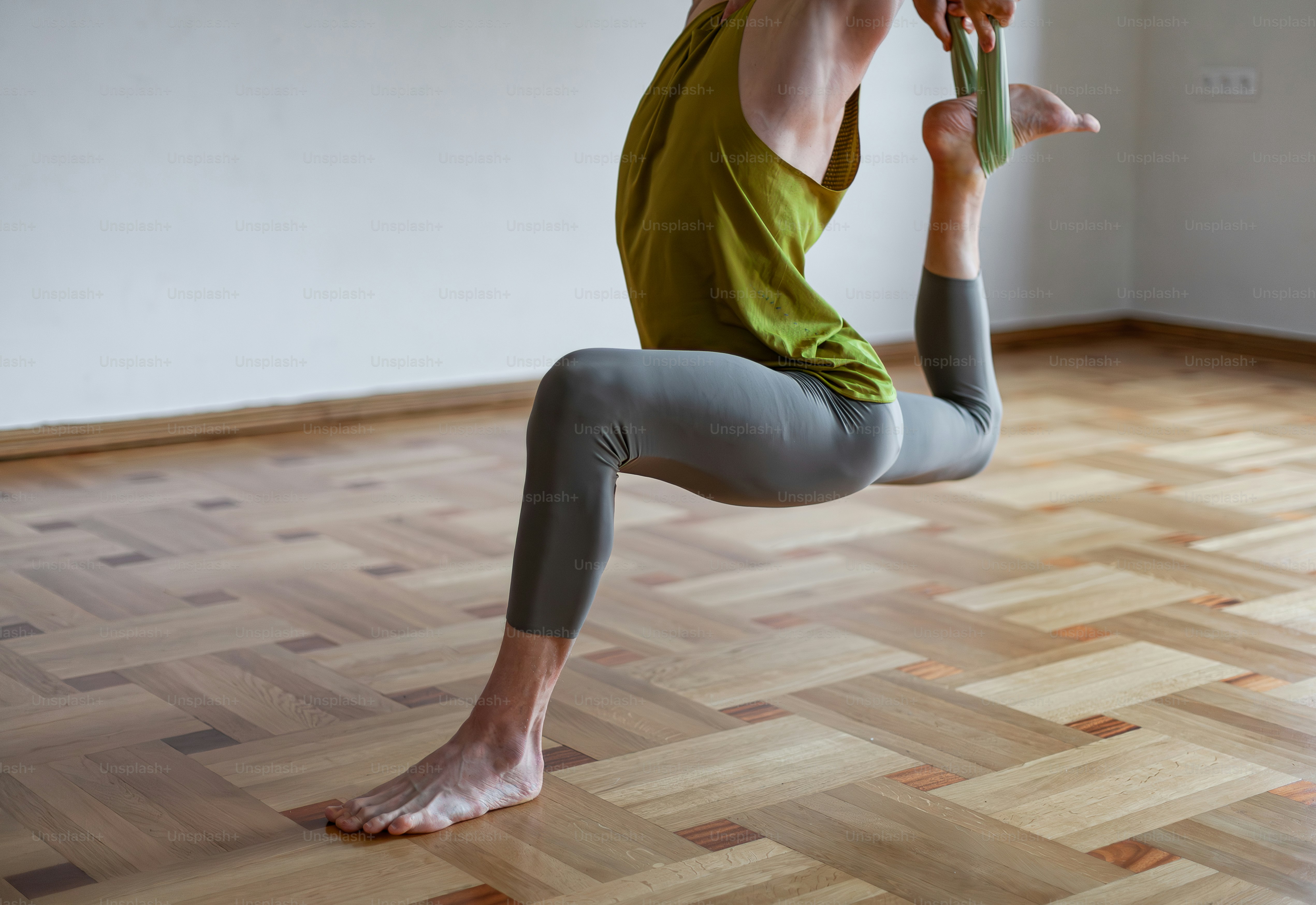 Une femme faisant une pose de yoga sur un plancher en bois