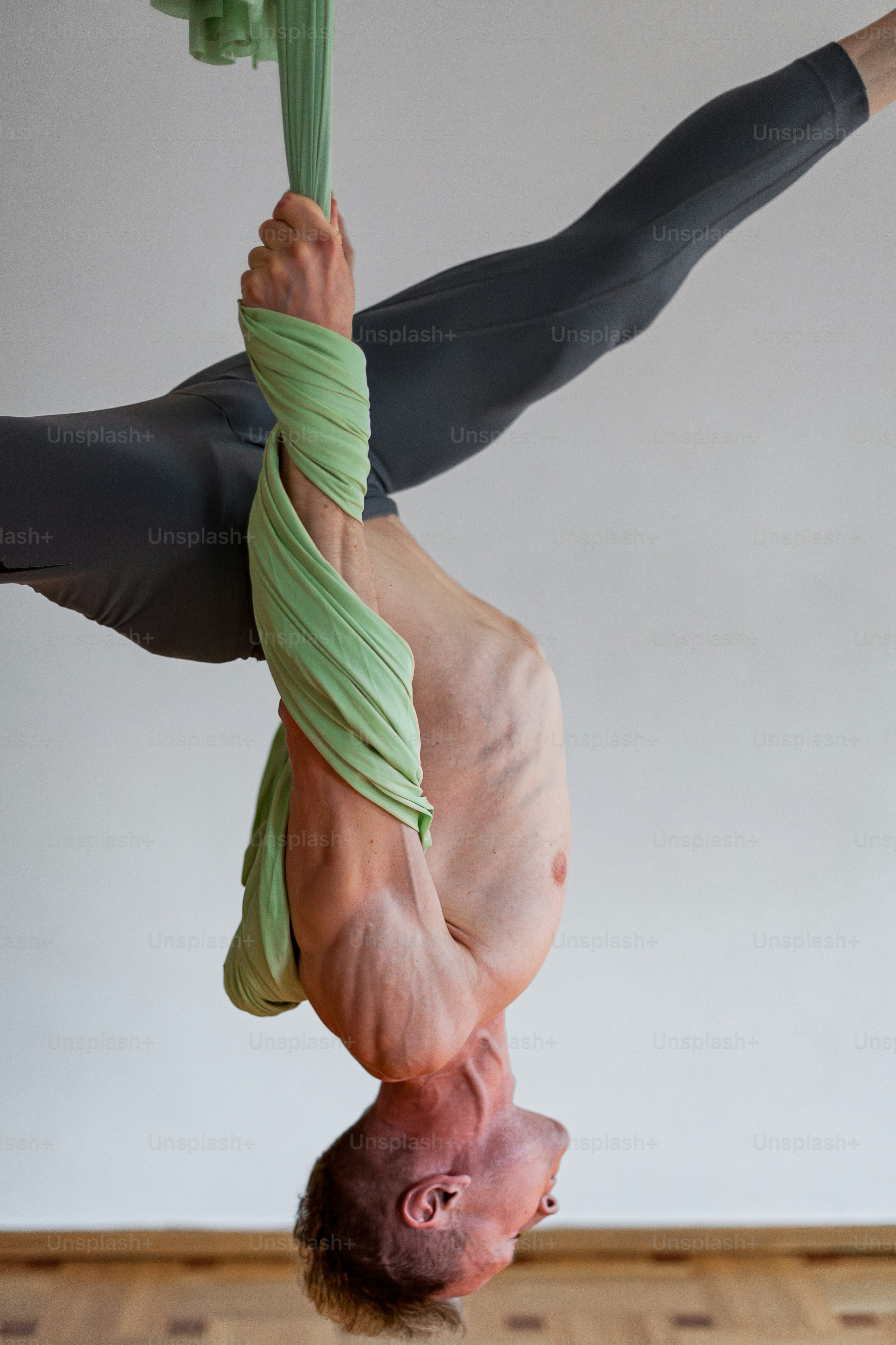 A man doing a handstand on a wooden floor