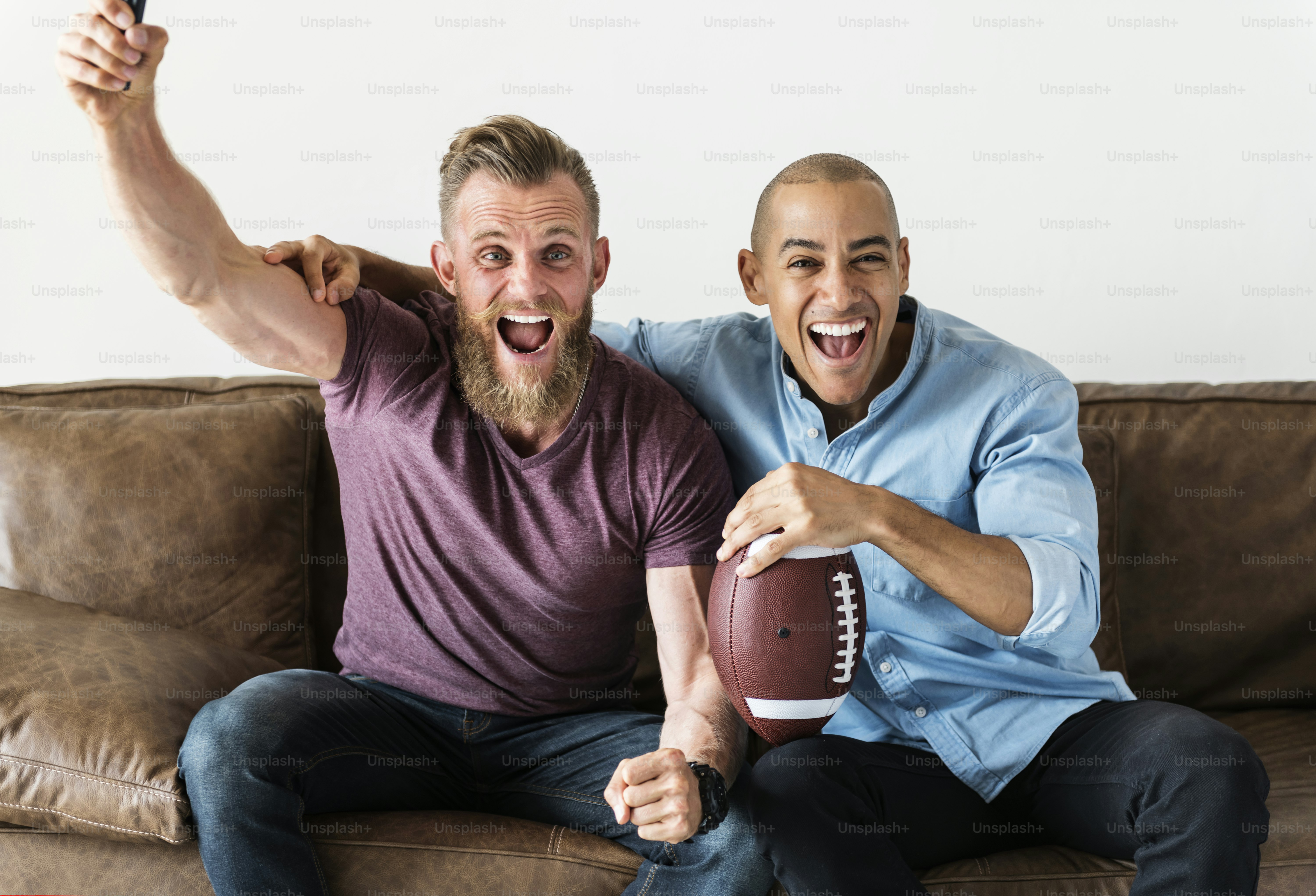 Man sitting together on a couch watching sport