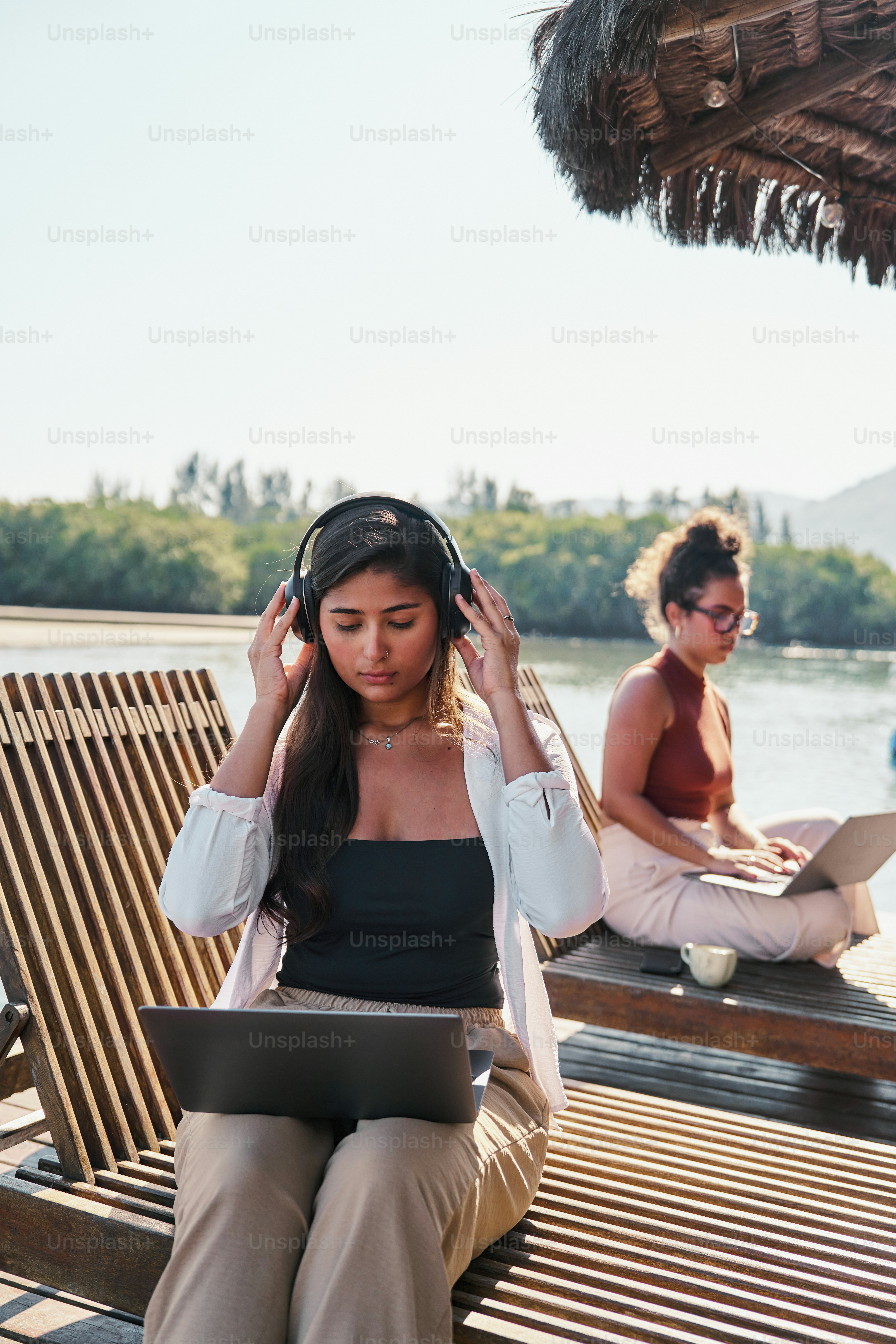 A woman sitting on a bench with headphones on