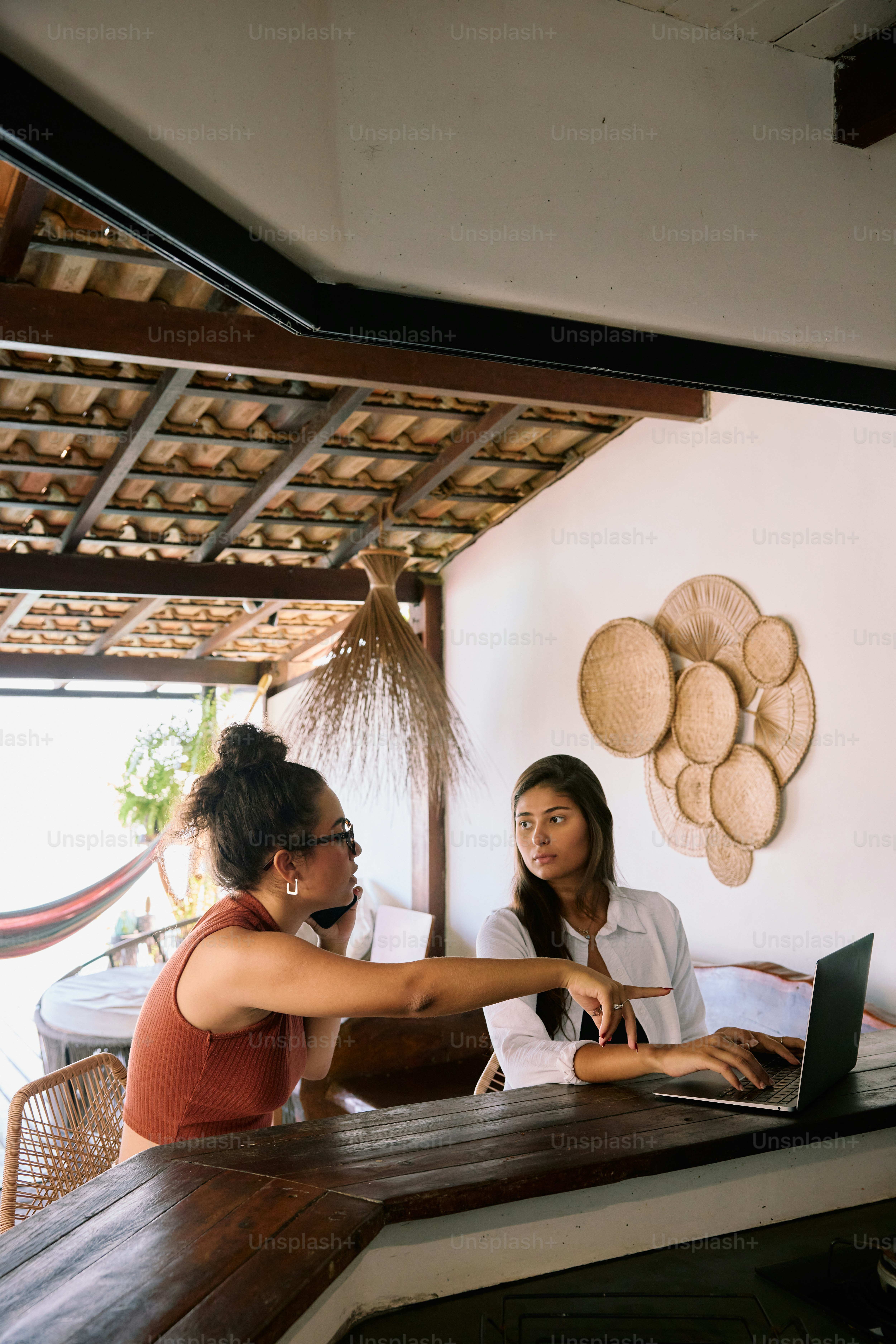 Two women sitting at a table with a laptop