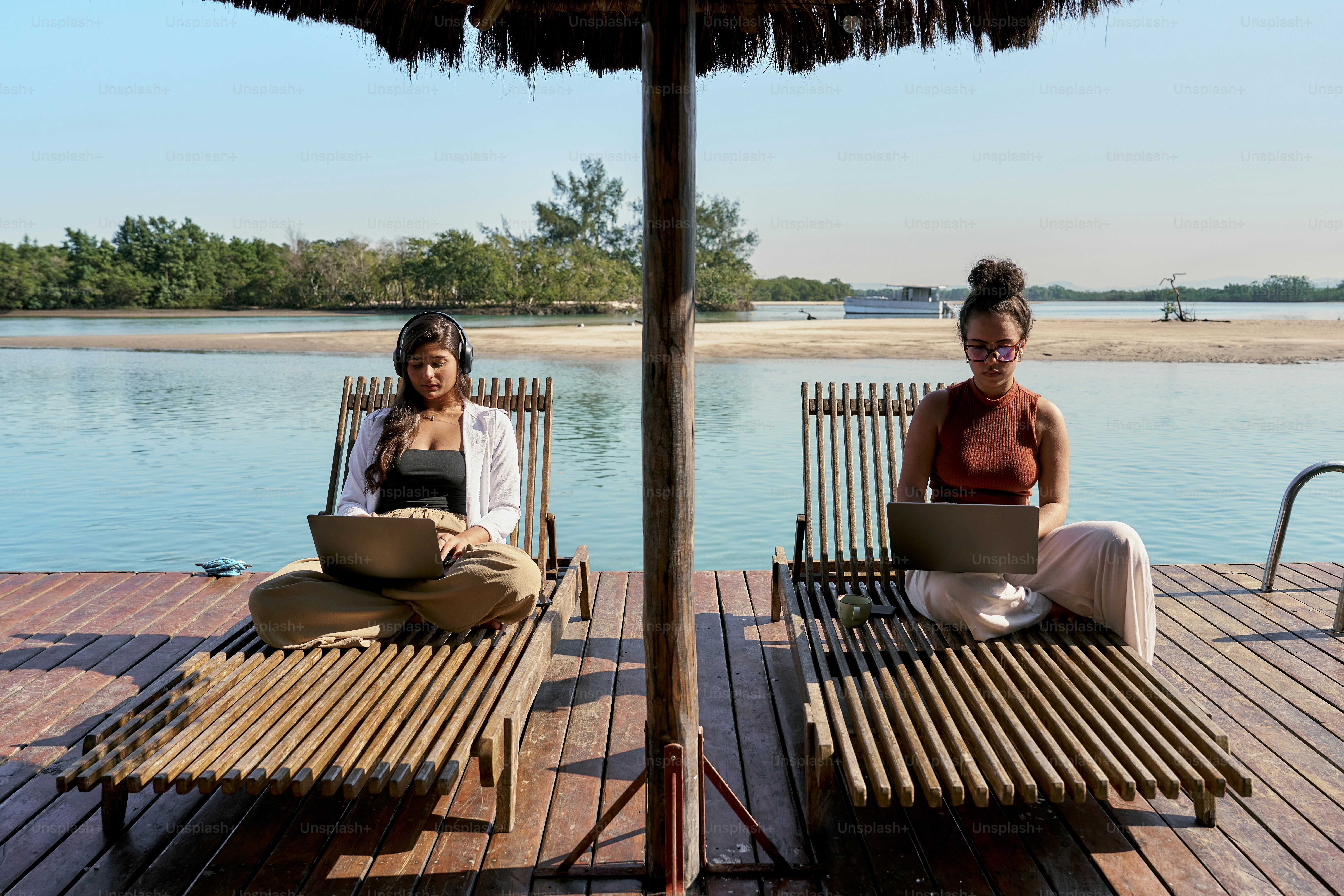 A couple of women sitting on top of a wooden deck