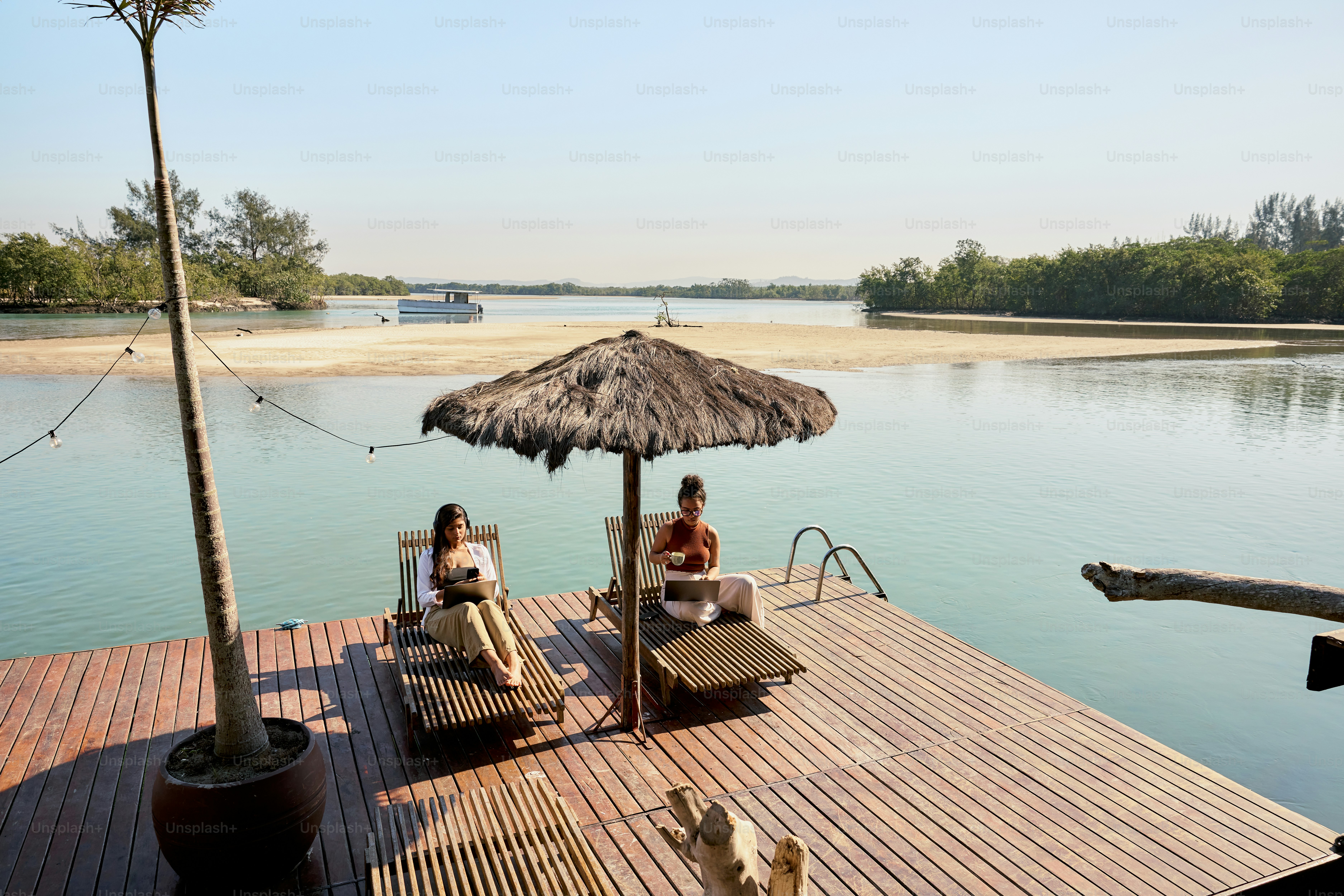 A couple of people sitting on top of a wooden dock