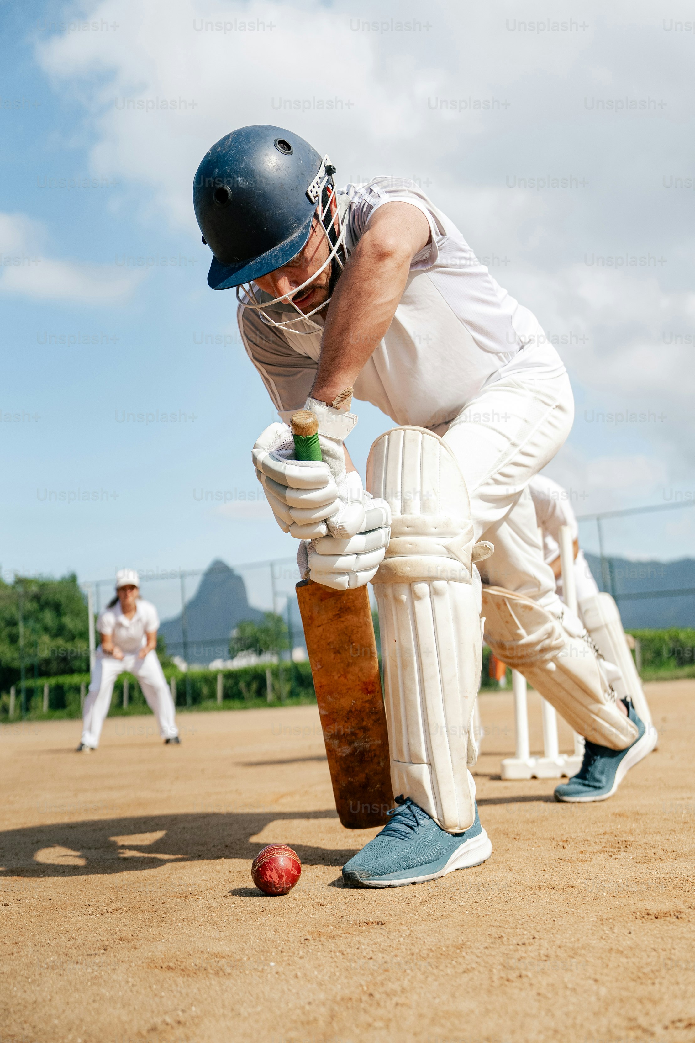 A man in a batting stance with a bat and ball