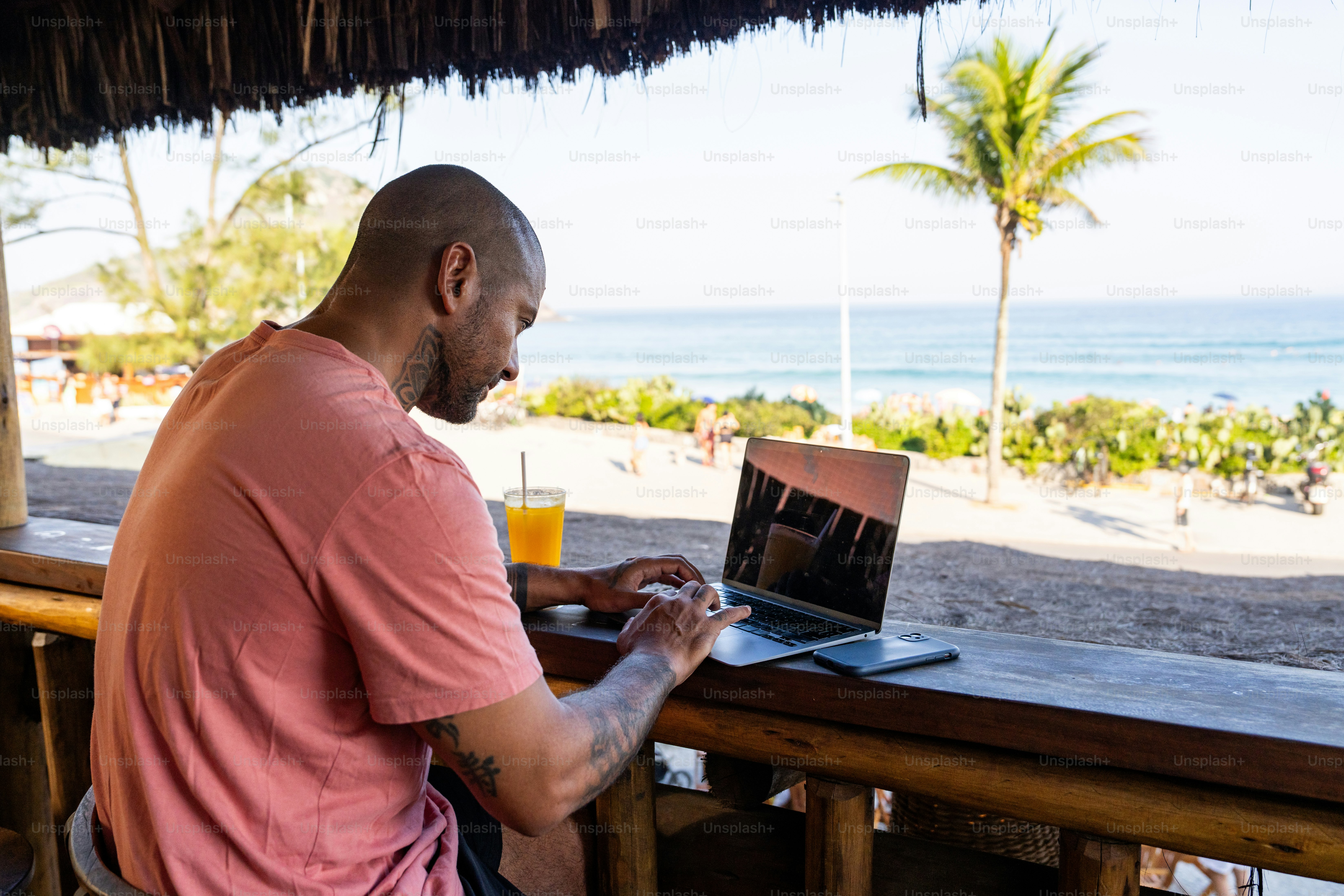 A man sitting at a table using a laptop computer