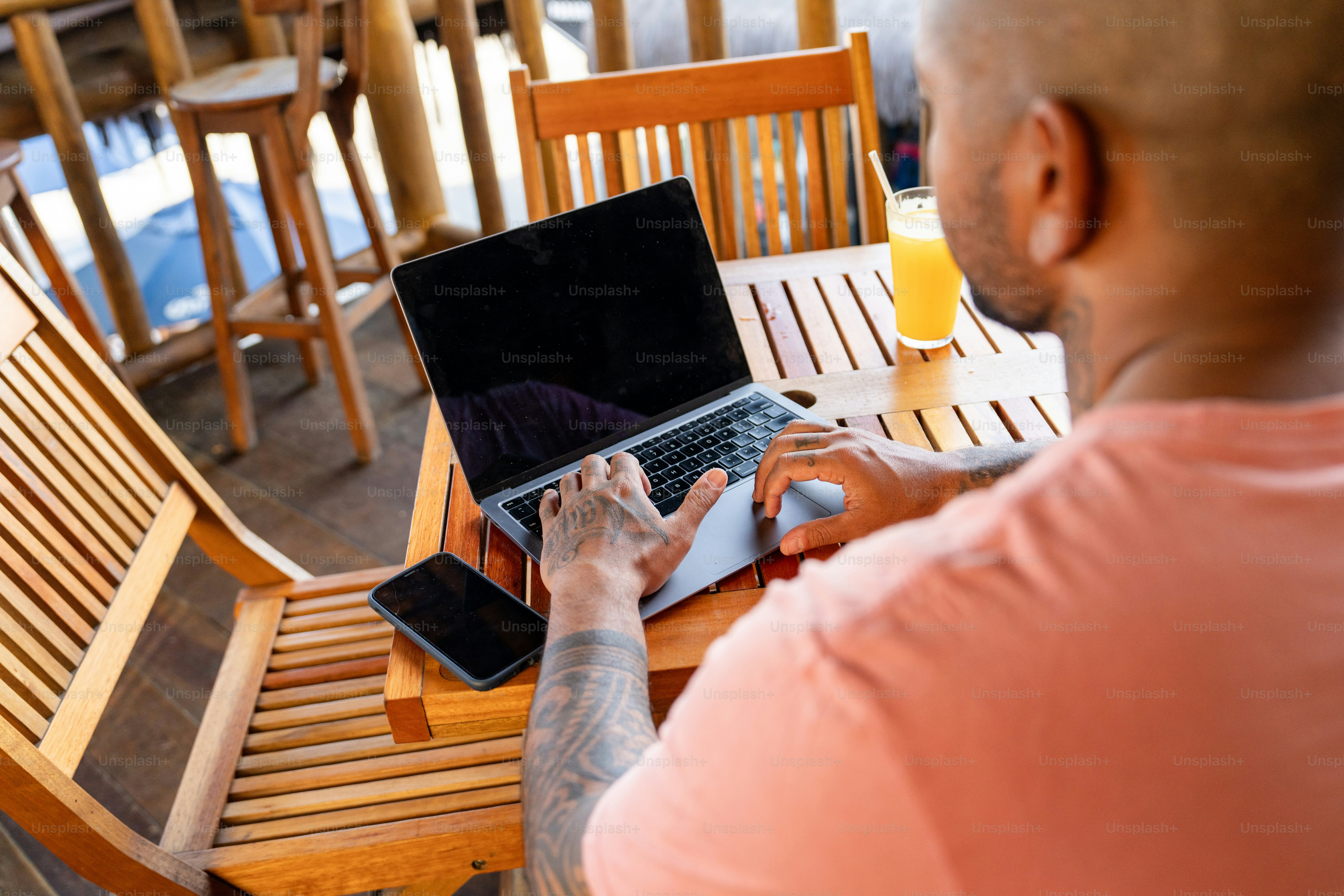 A man sitting at a table using a laptop computer