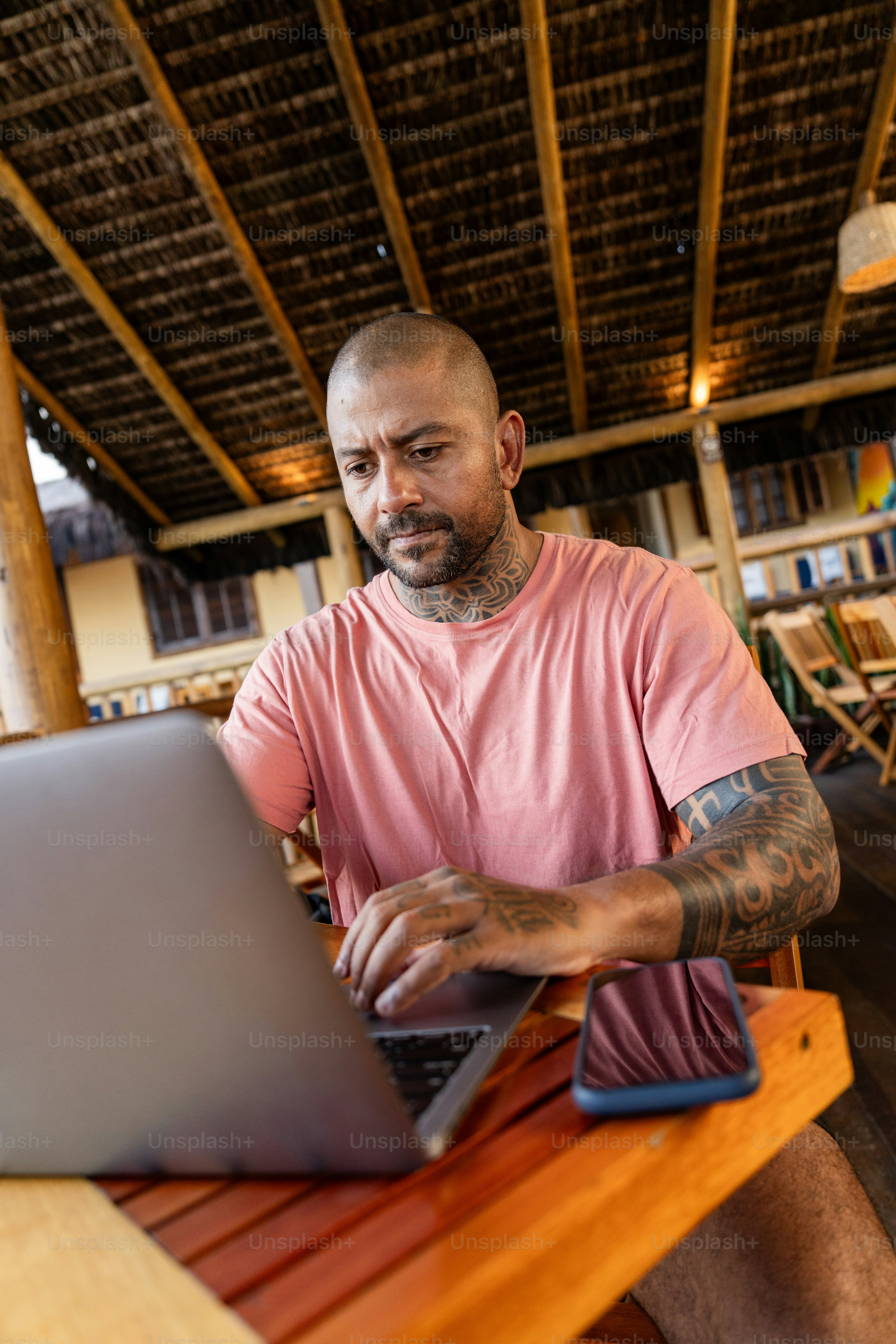 A man sitting at a table using a laptop computer