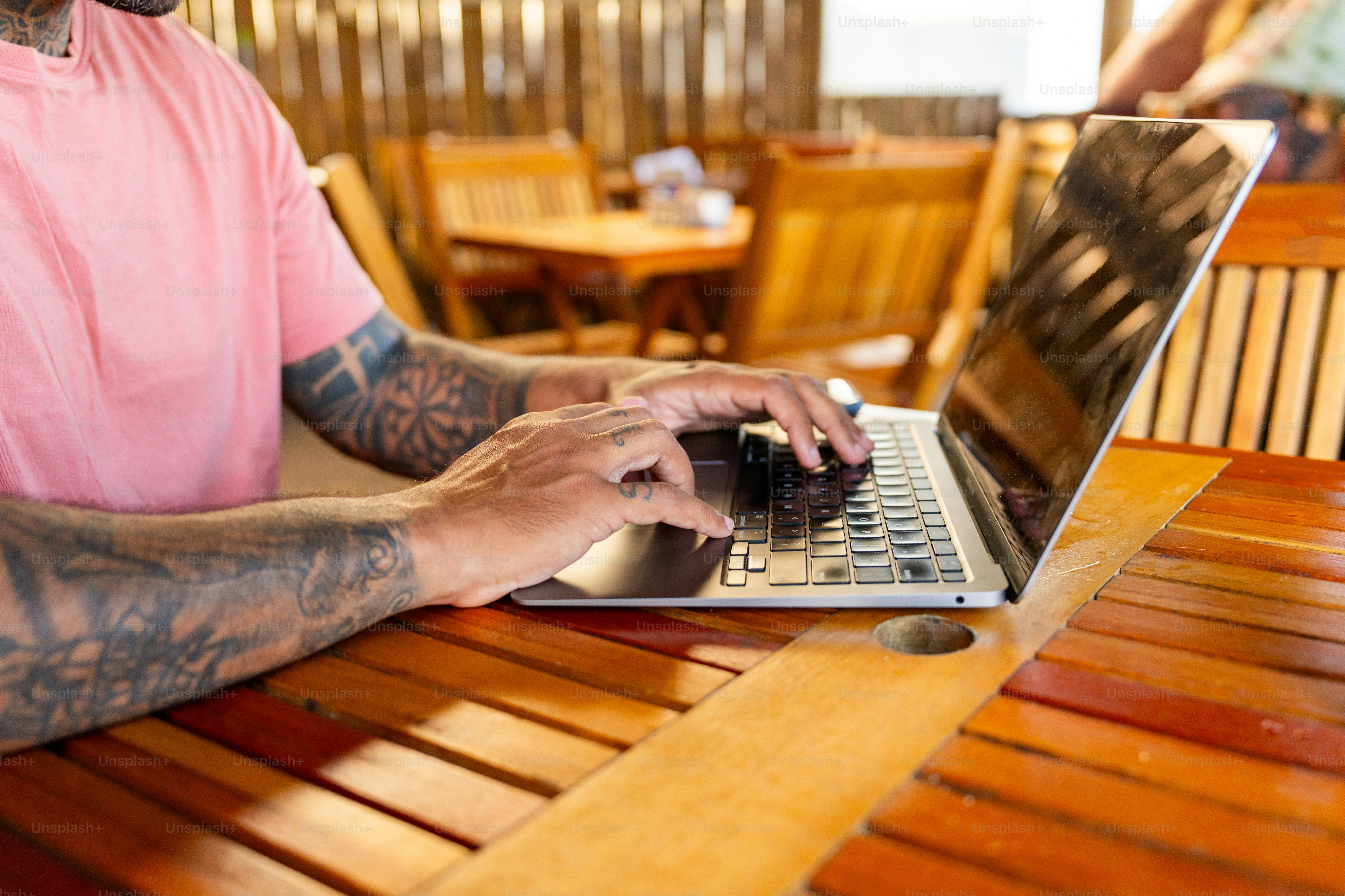 A man sitting at a table using a laptop computer