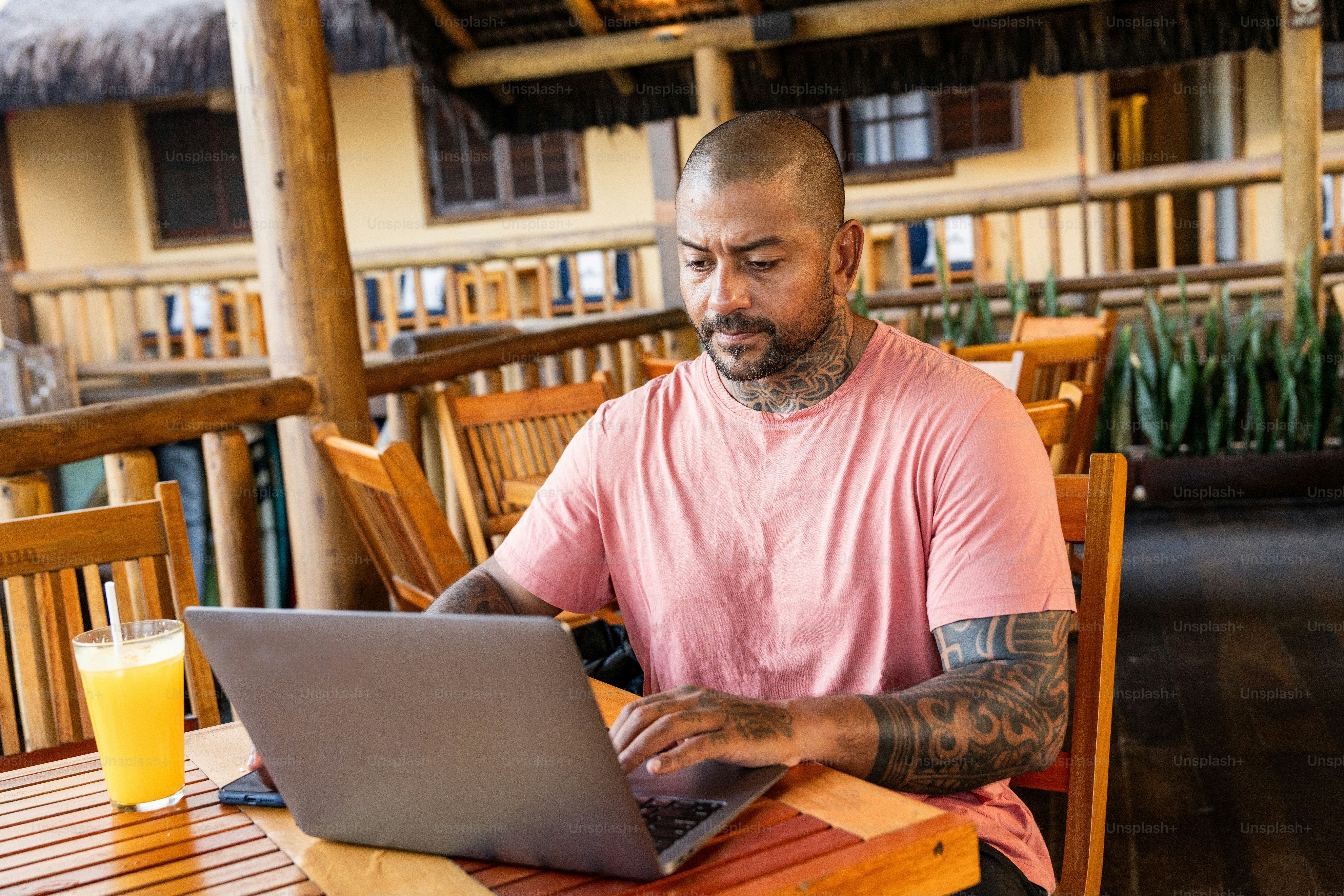 A man sitting at a table using a laptop computer