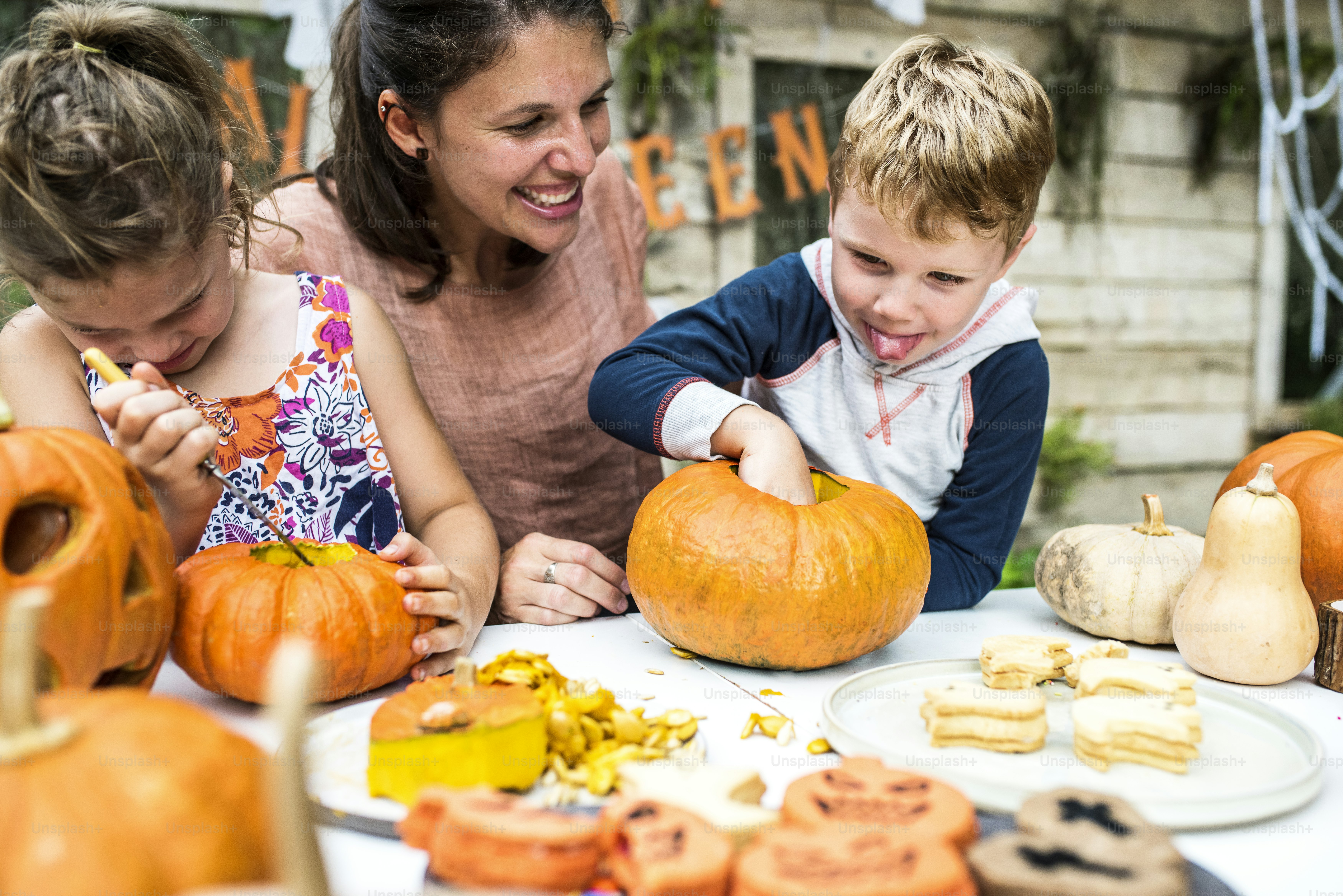Junge Kinder schnitzen Halloween-Kürbislaternen