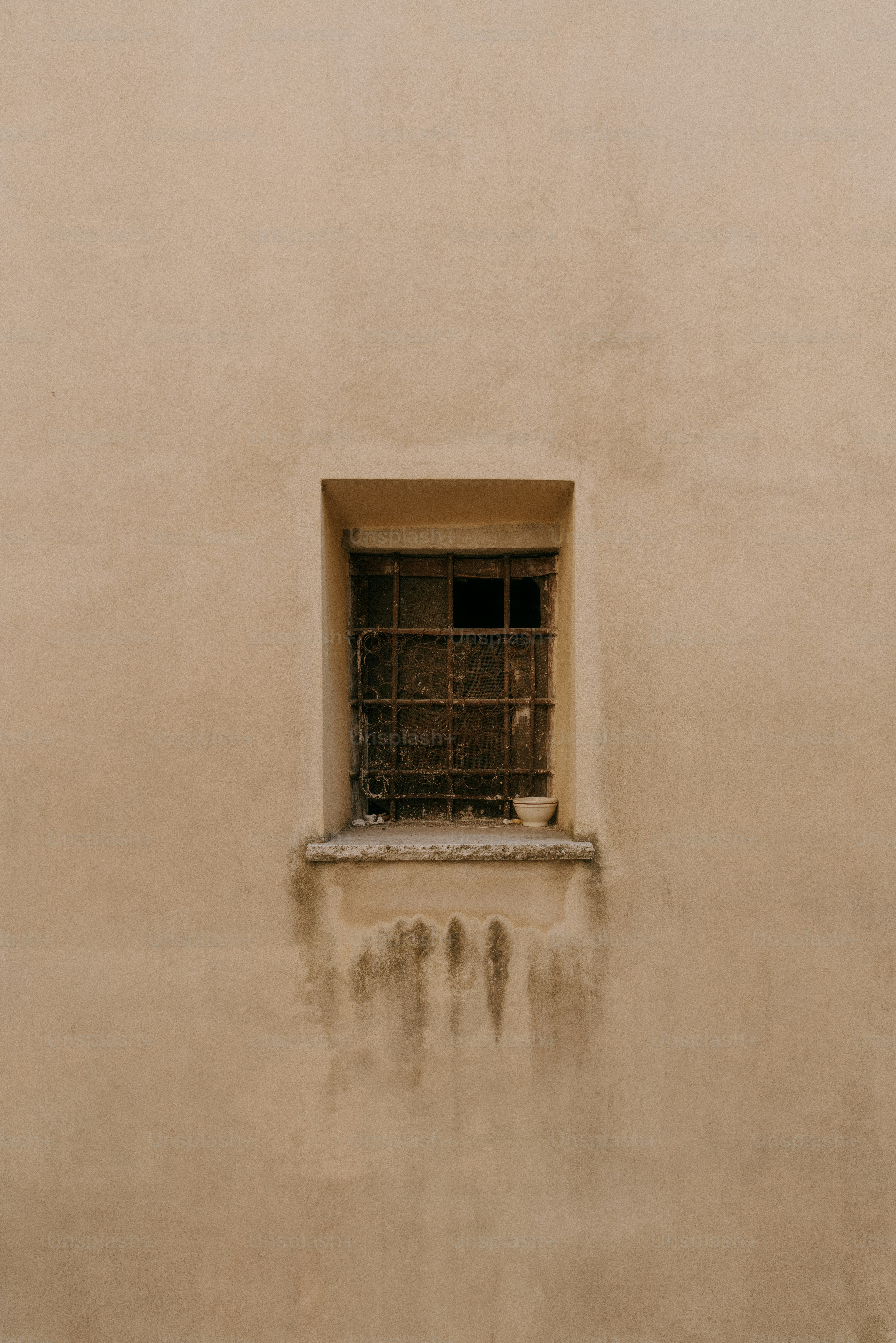 A window with bars on the side of a building