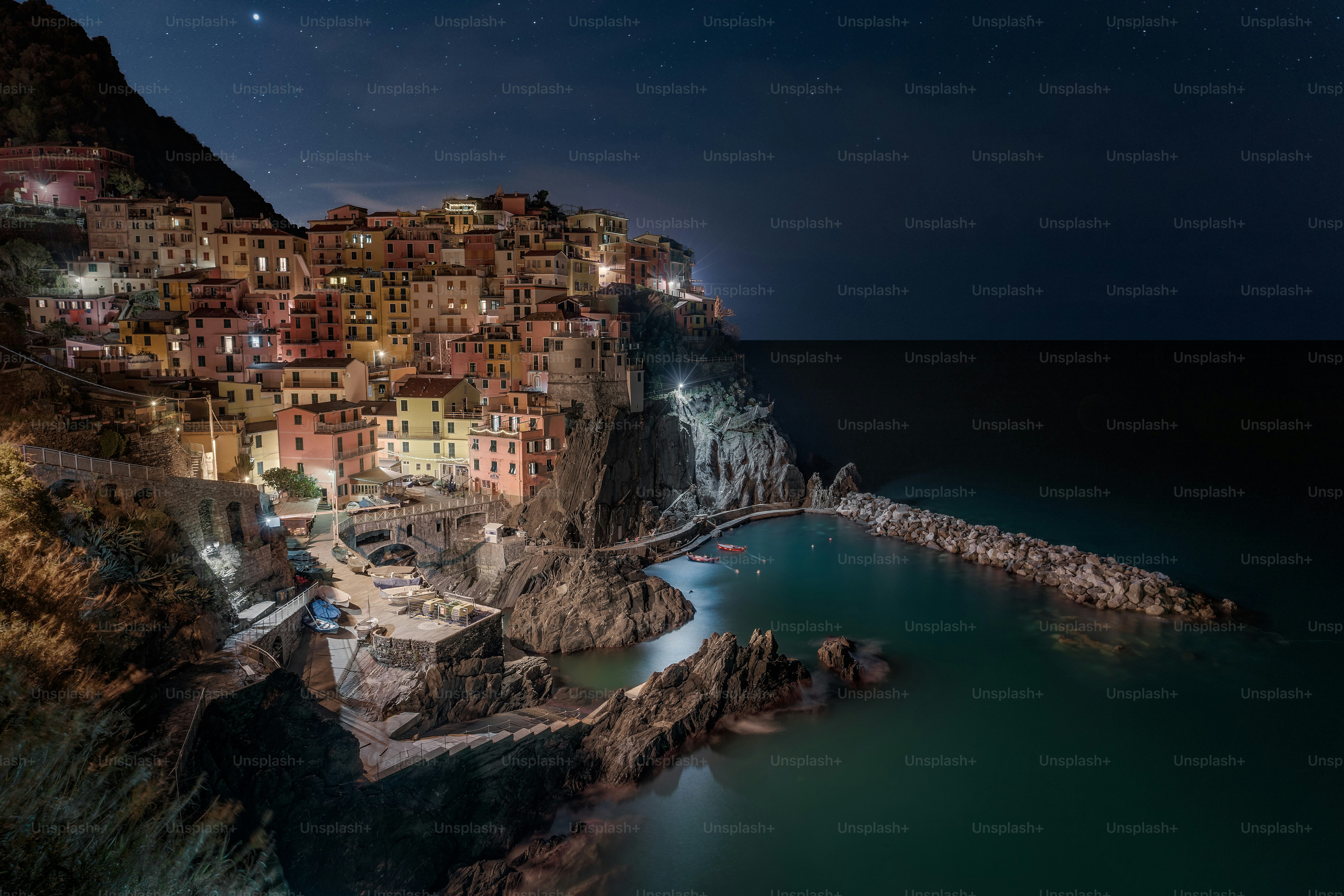 A night time view of a town on a cliff