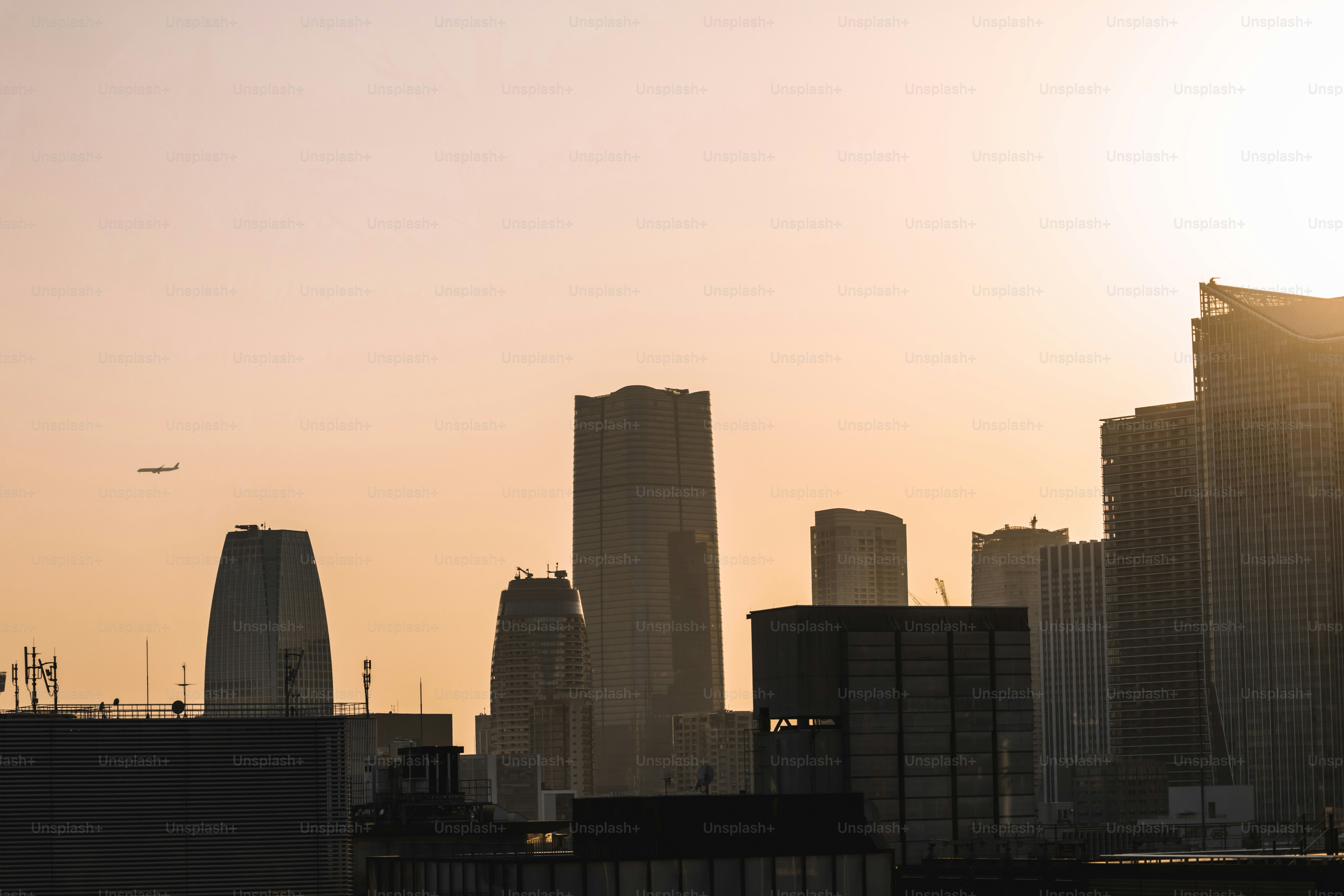 Un horizonte de la ciudad con un avión volando en el cielo