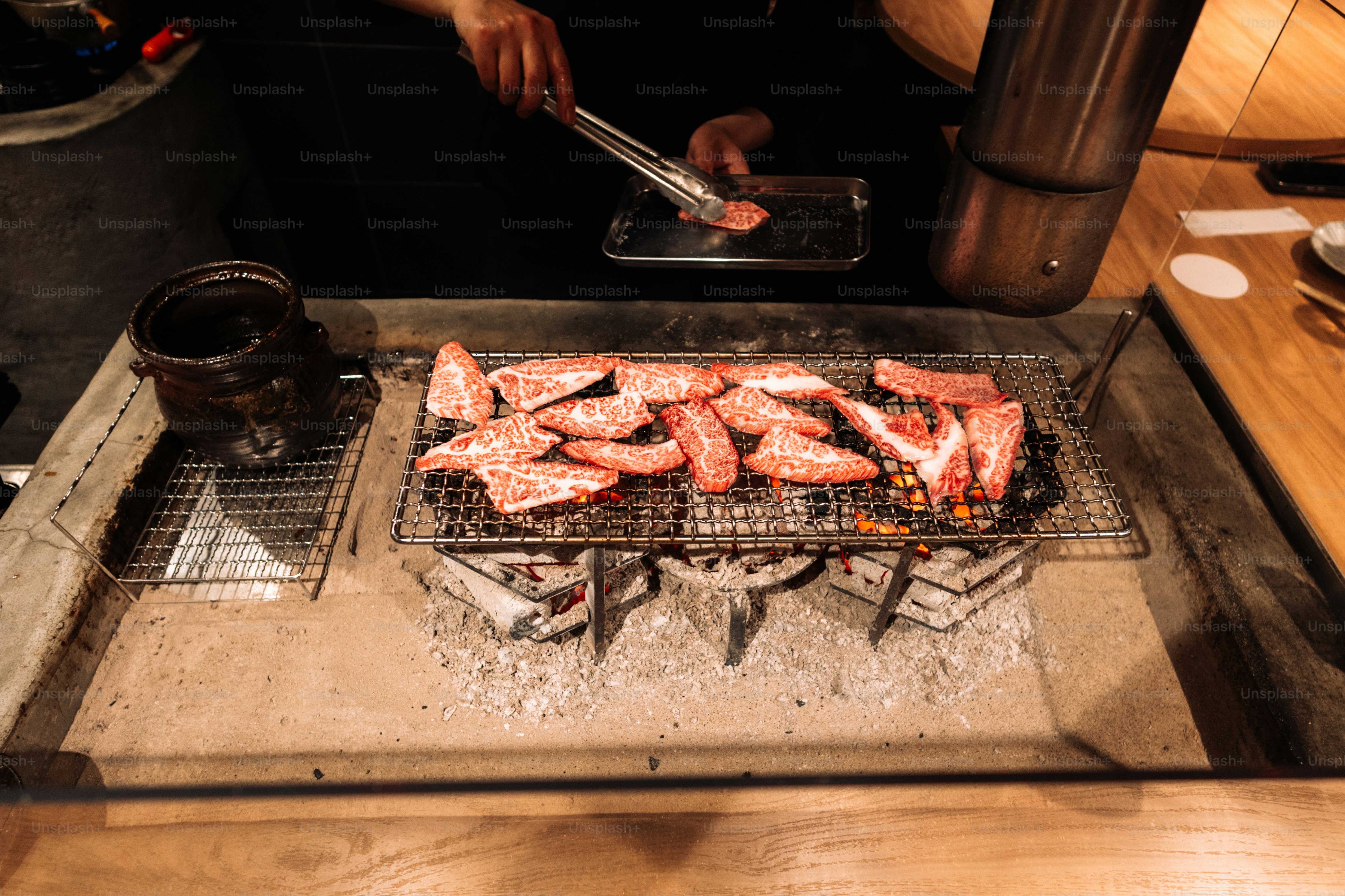 A person cooking food on a grill in a kitchen