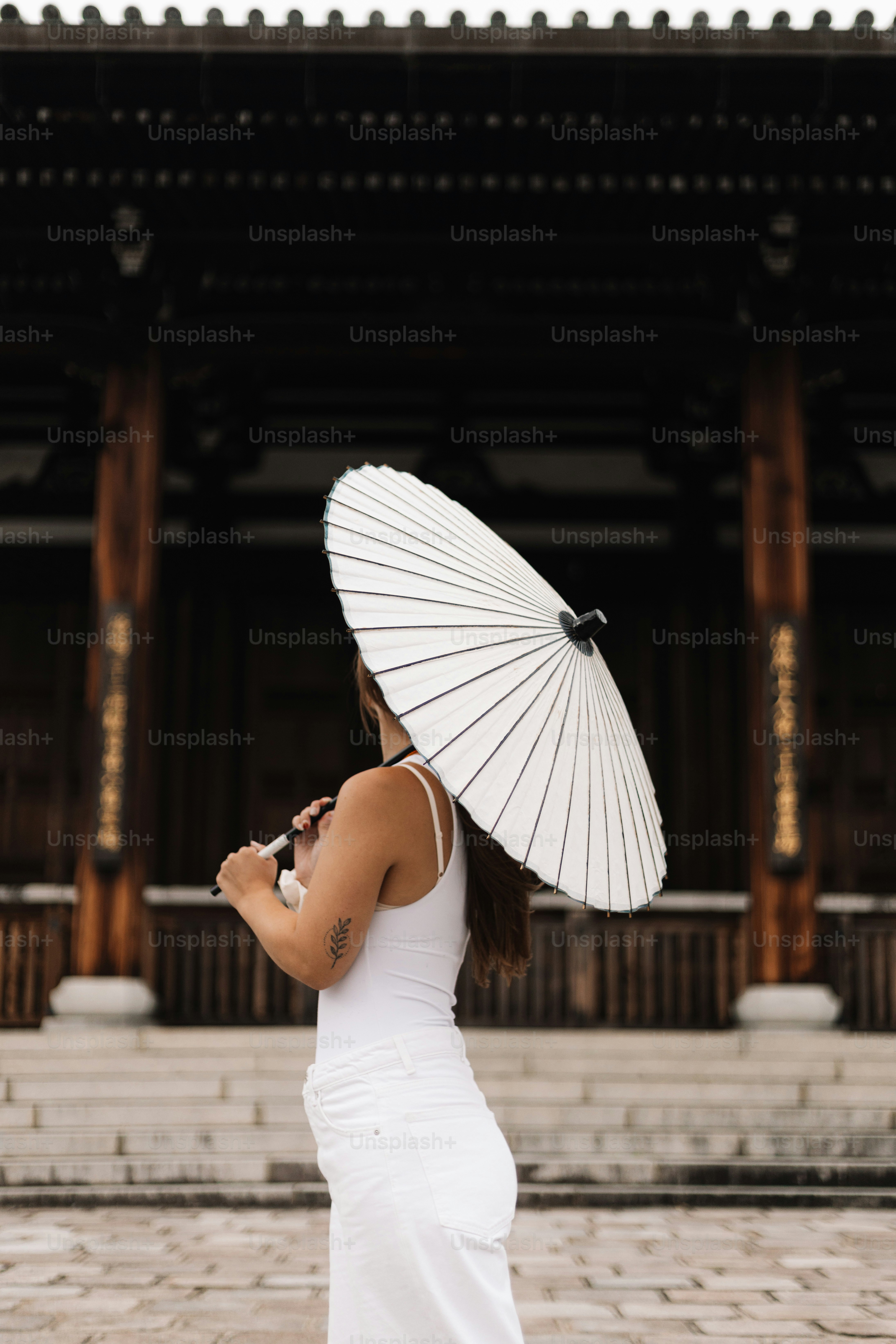 Una mujer con un vestido blanco sosteniendo un paraguas