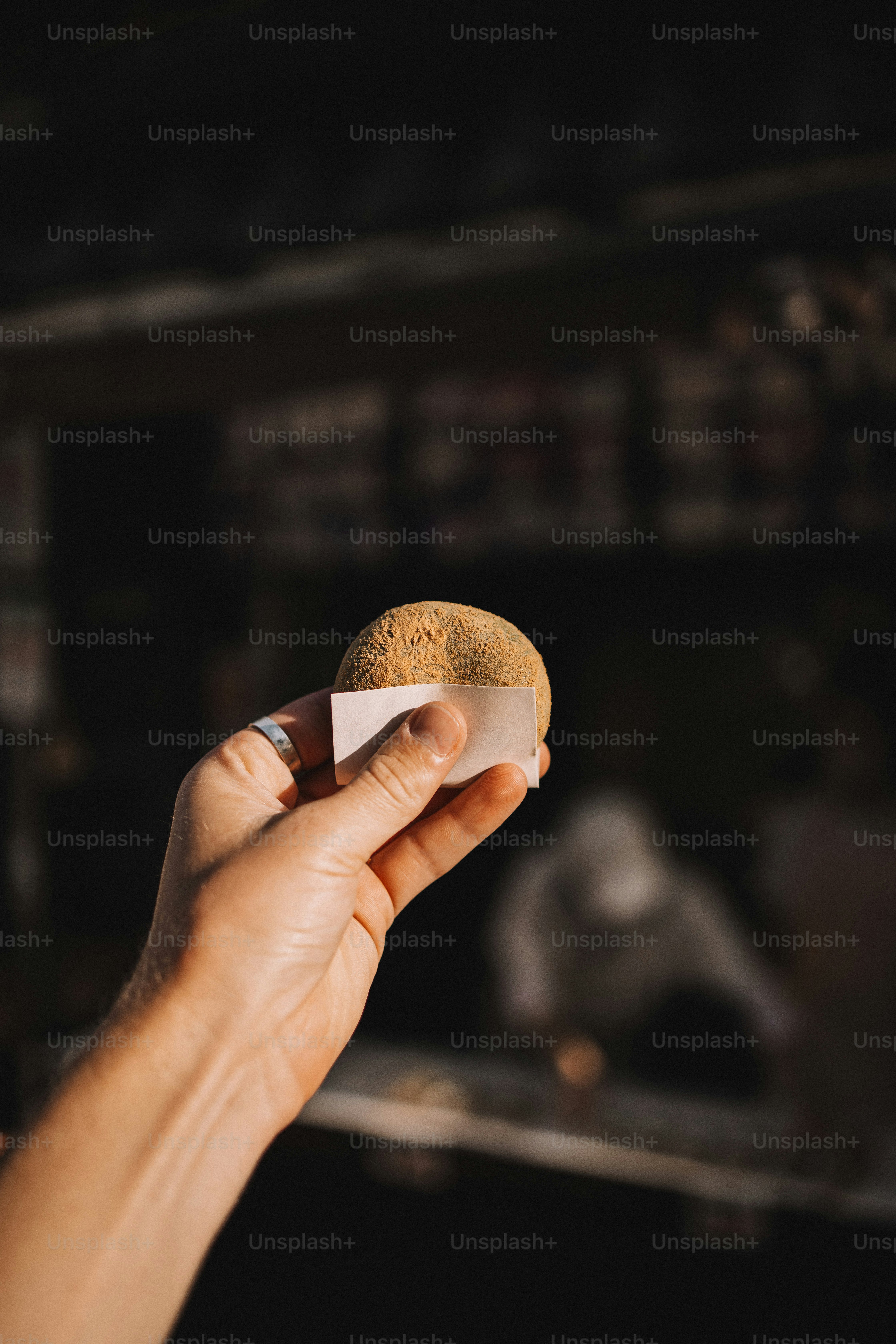 A person holding a piece of bread in their hand