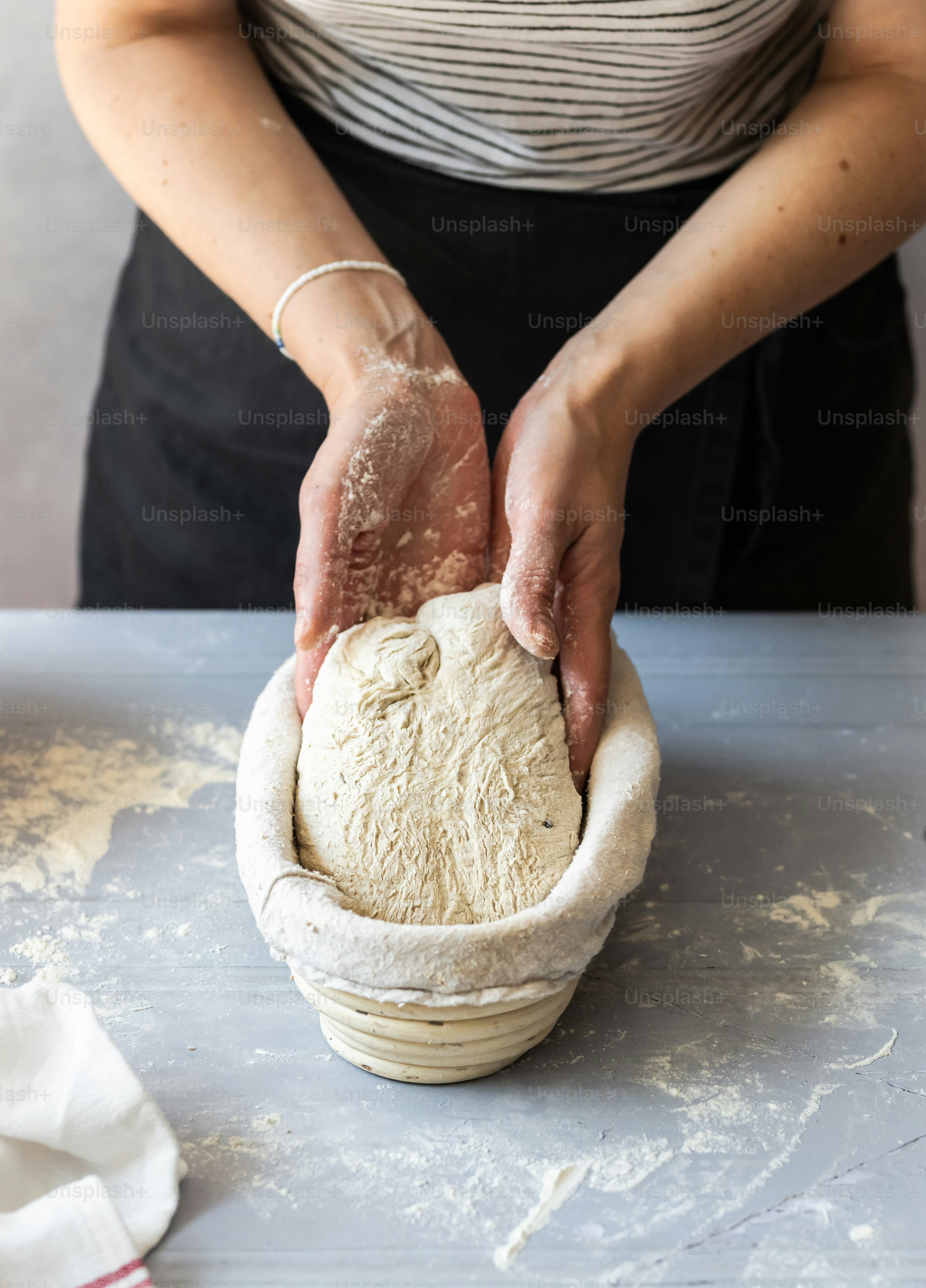 A woman is kneading dough into a bowl