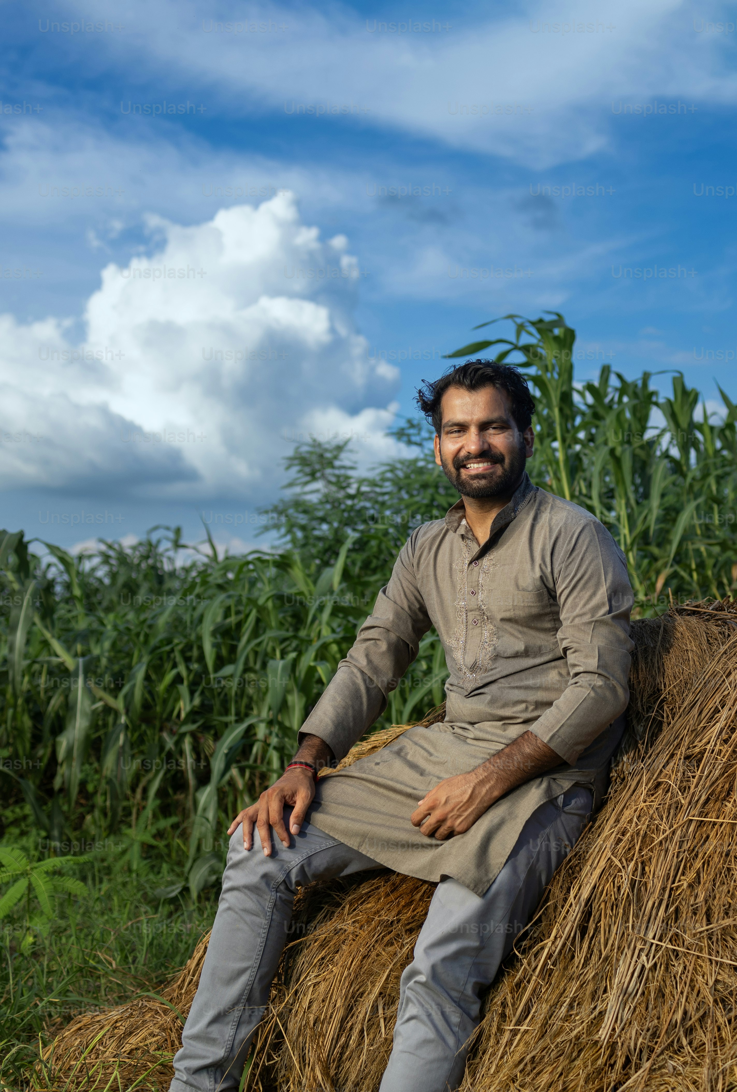 A man sitting on top of a pile of hay