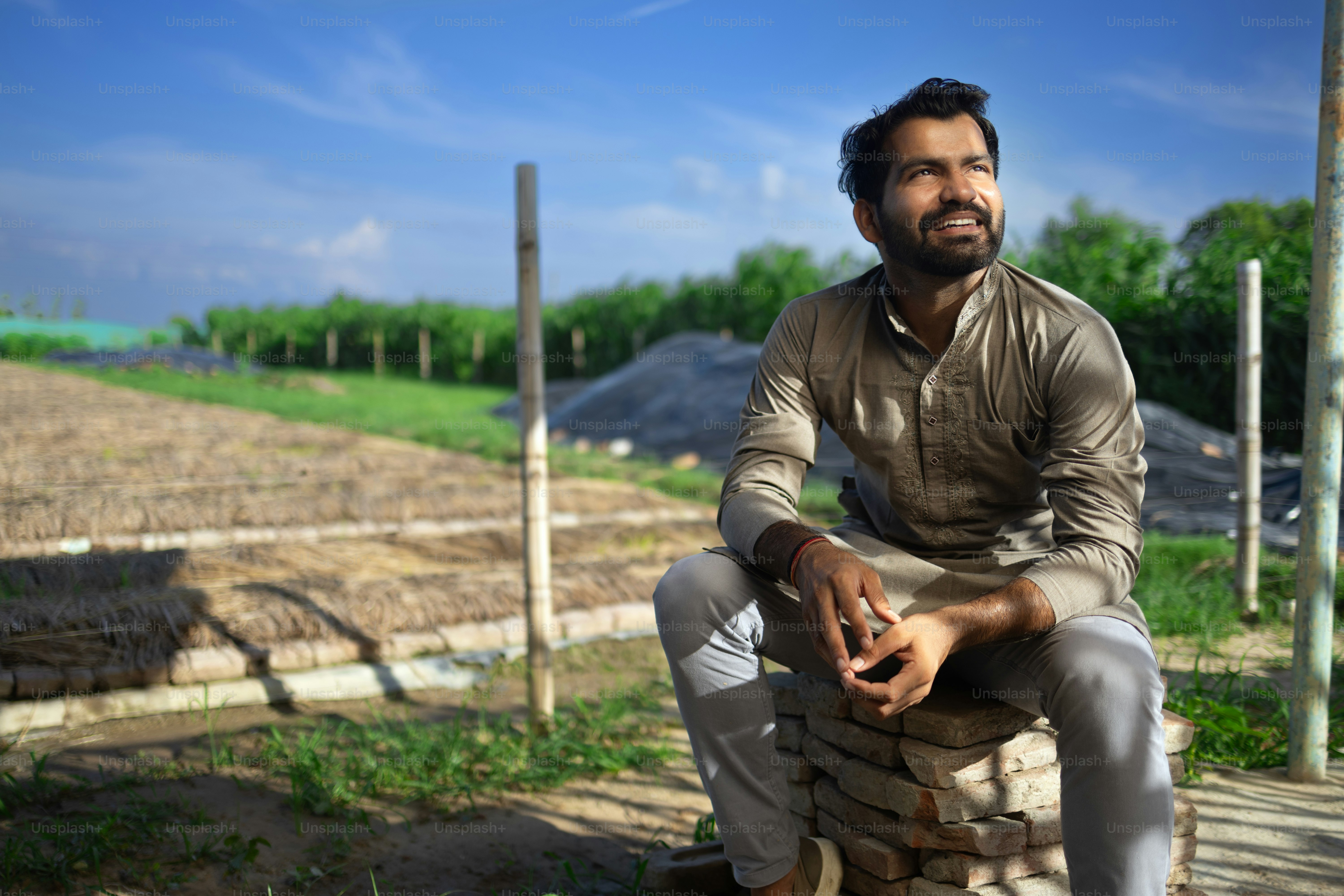A man sitting on top of a pile of dirt