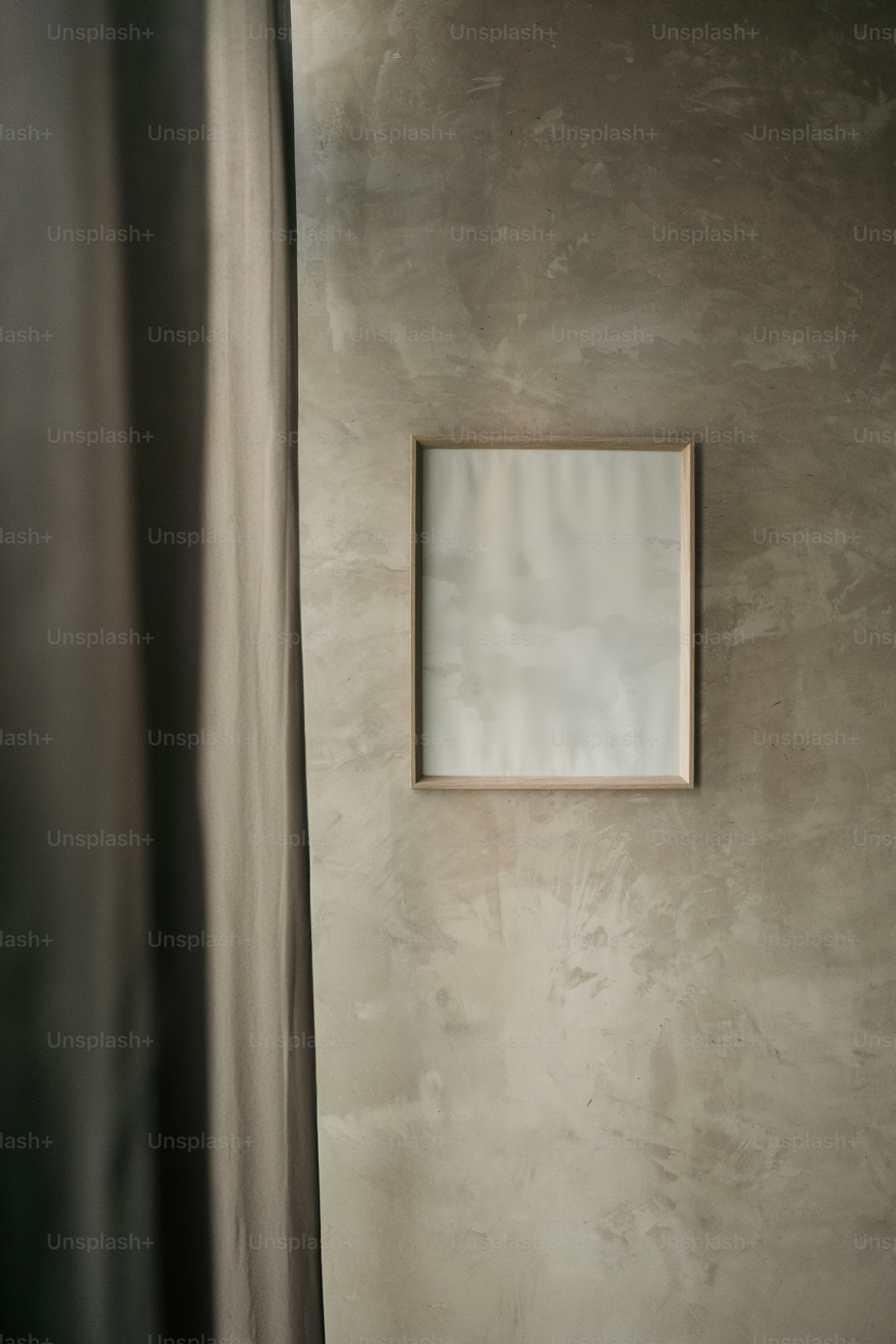 カーテンの横の壁に掛けられた額縁