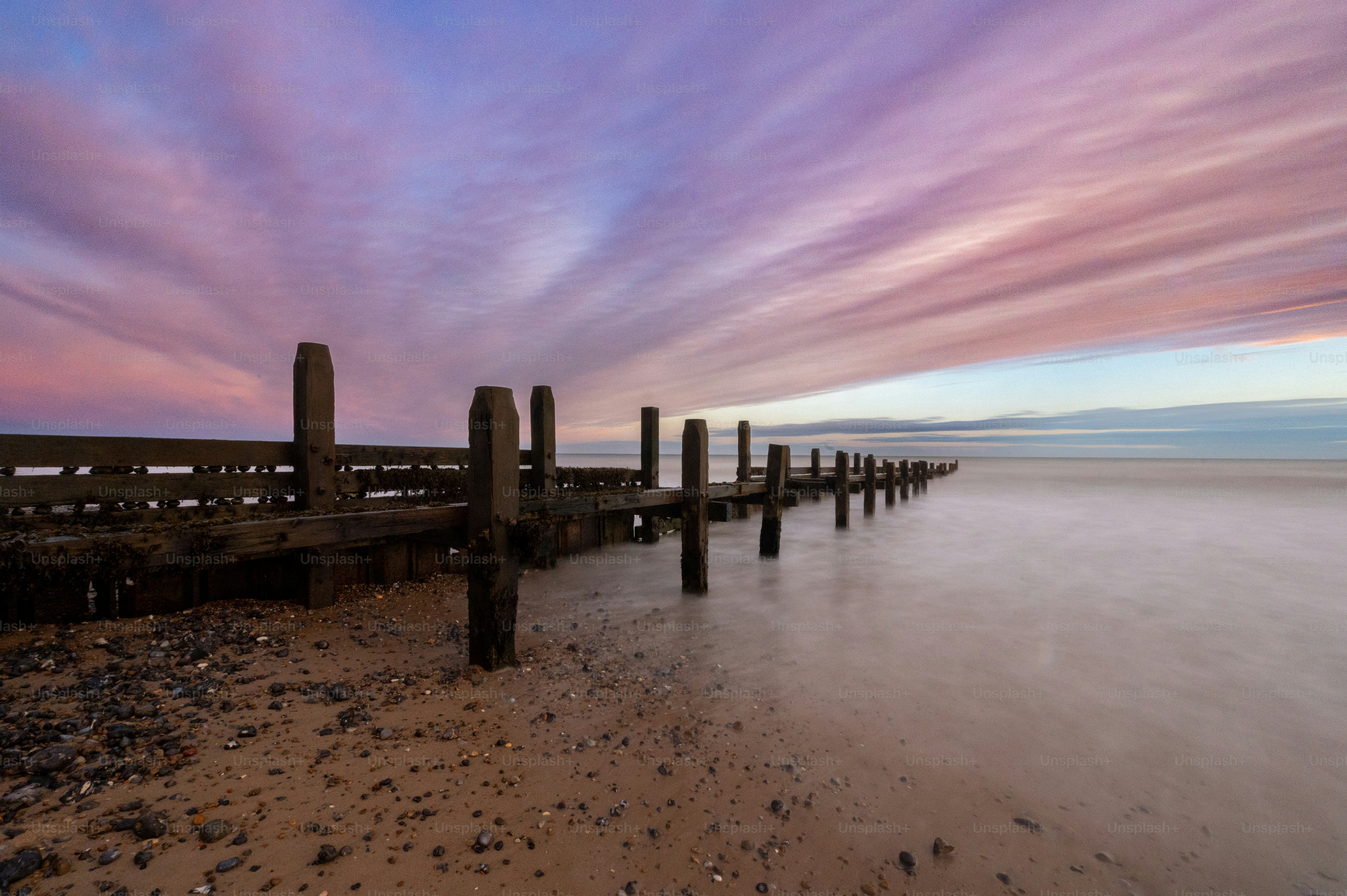 A long exposure photo of a beach at sunset