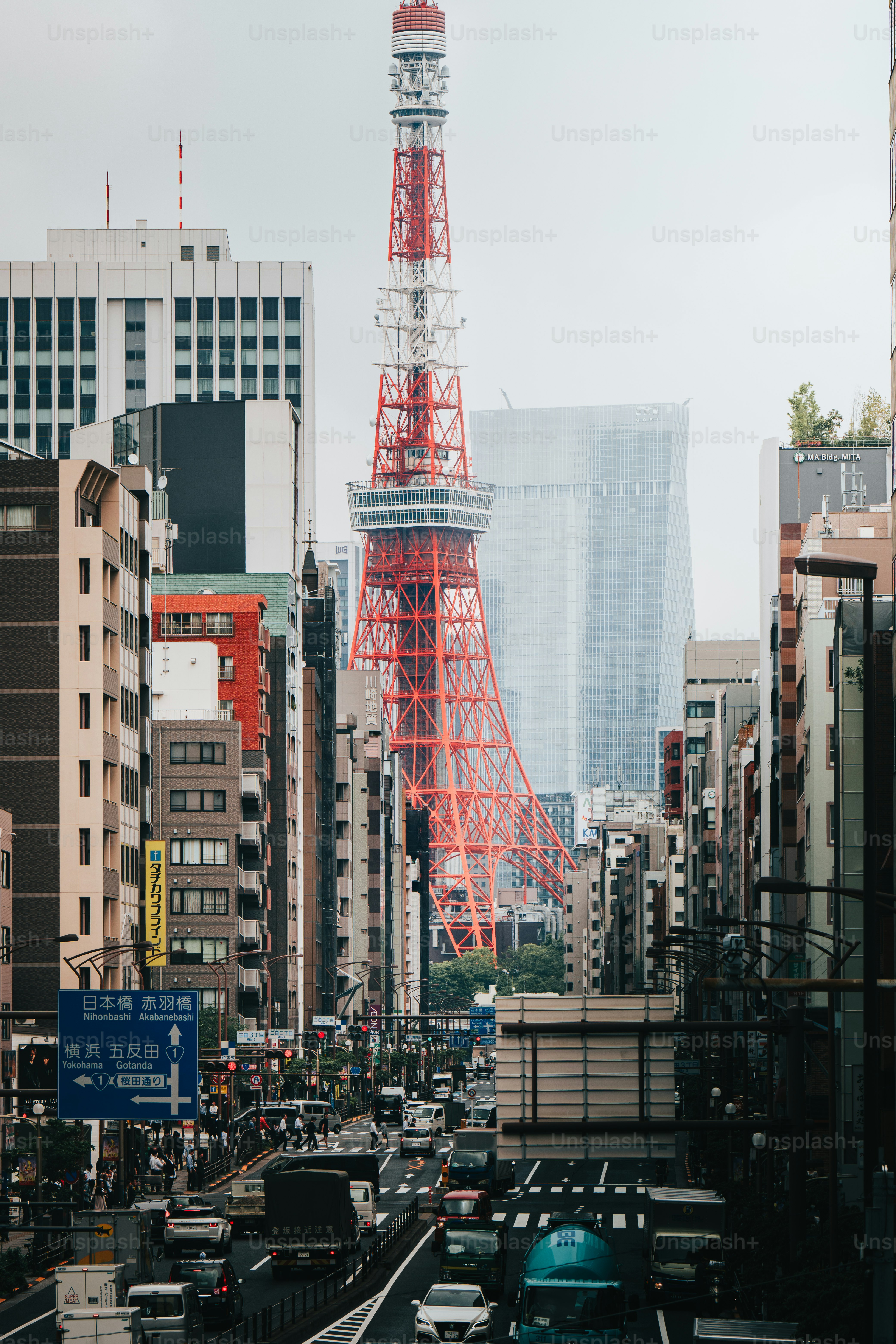 A busy city street with a red tower in the background