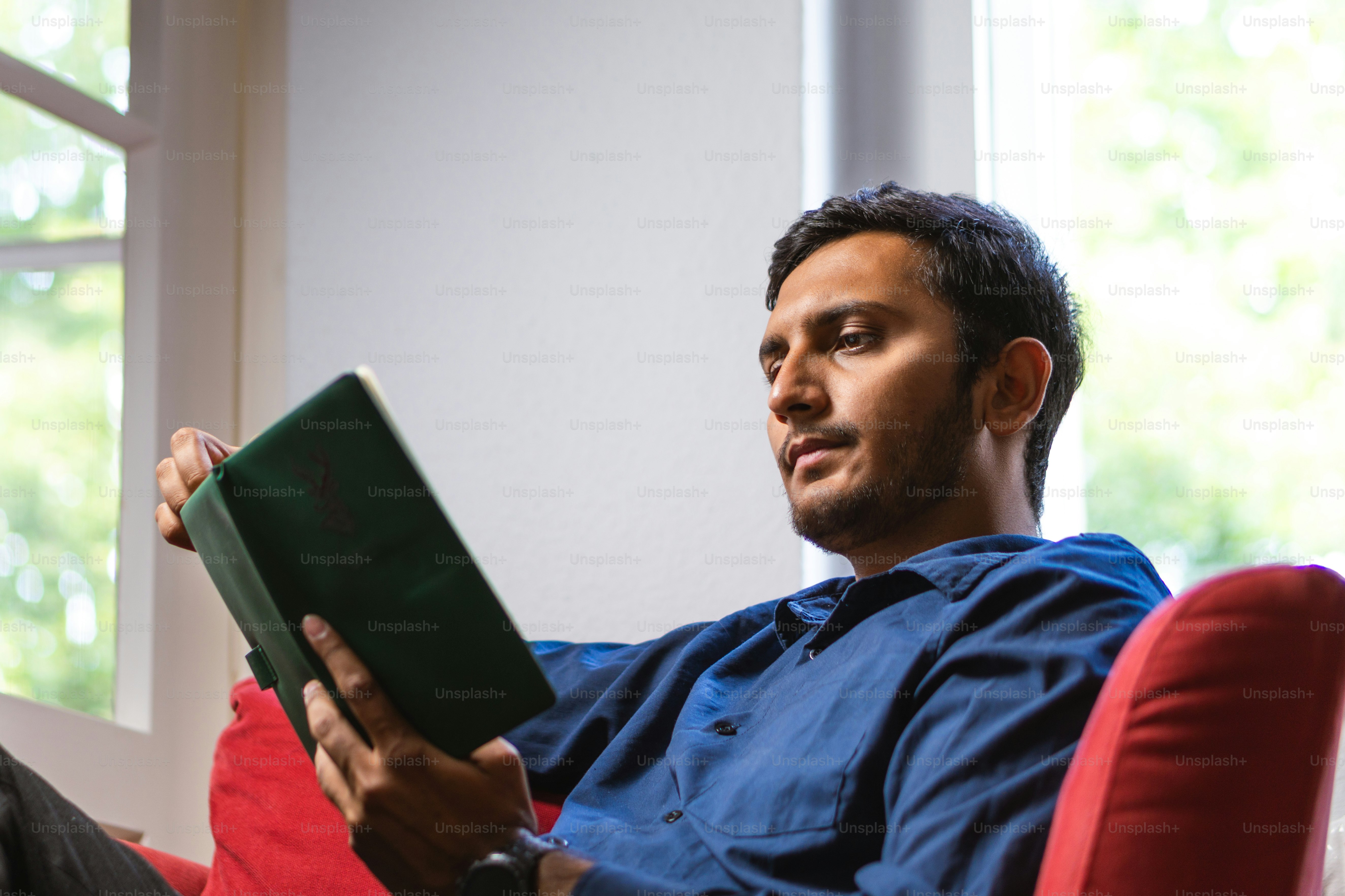 A man sitting in a chair reading a book