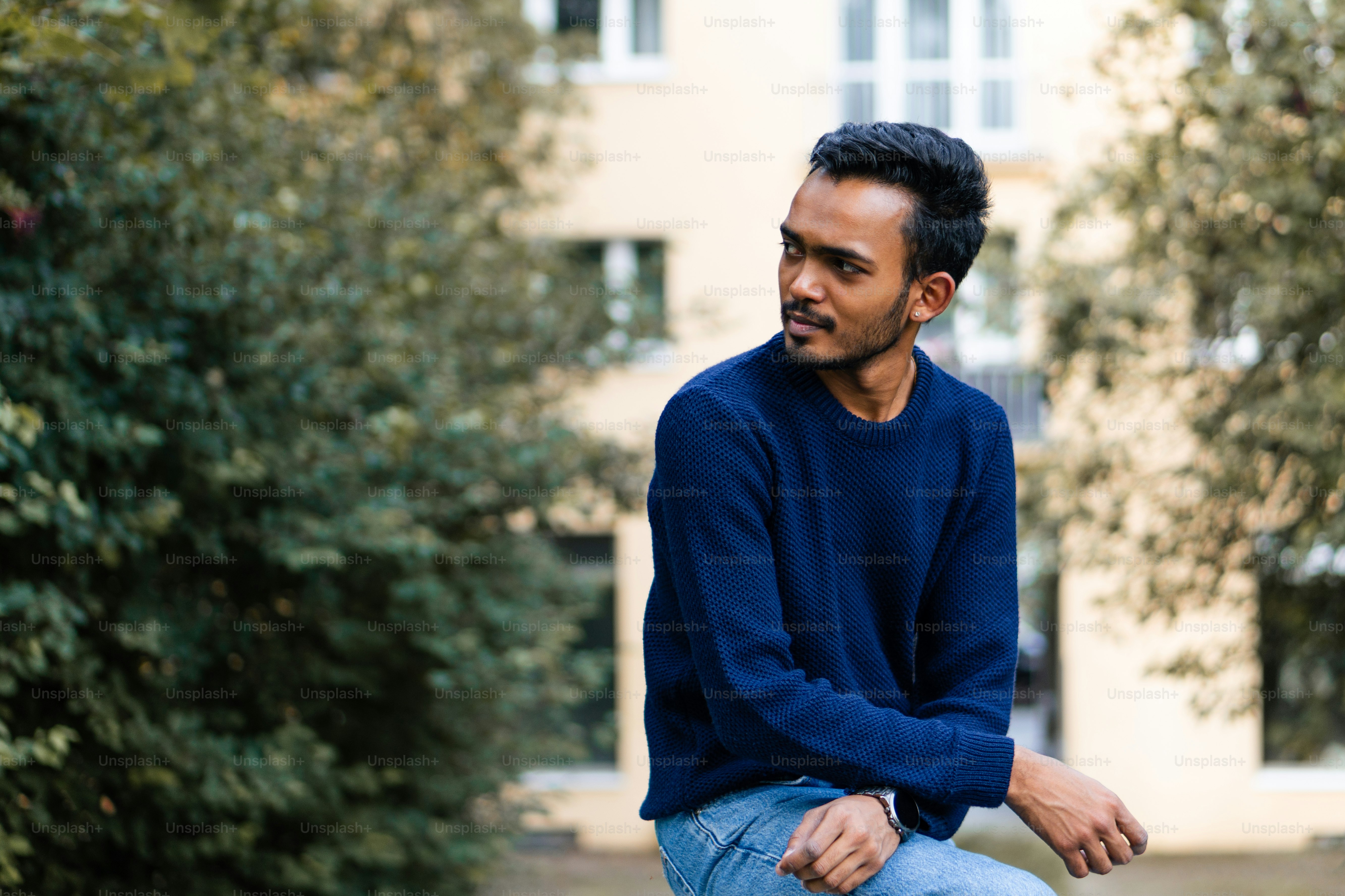 A man sitting on a bench in front of a building