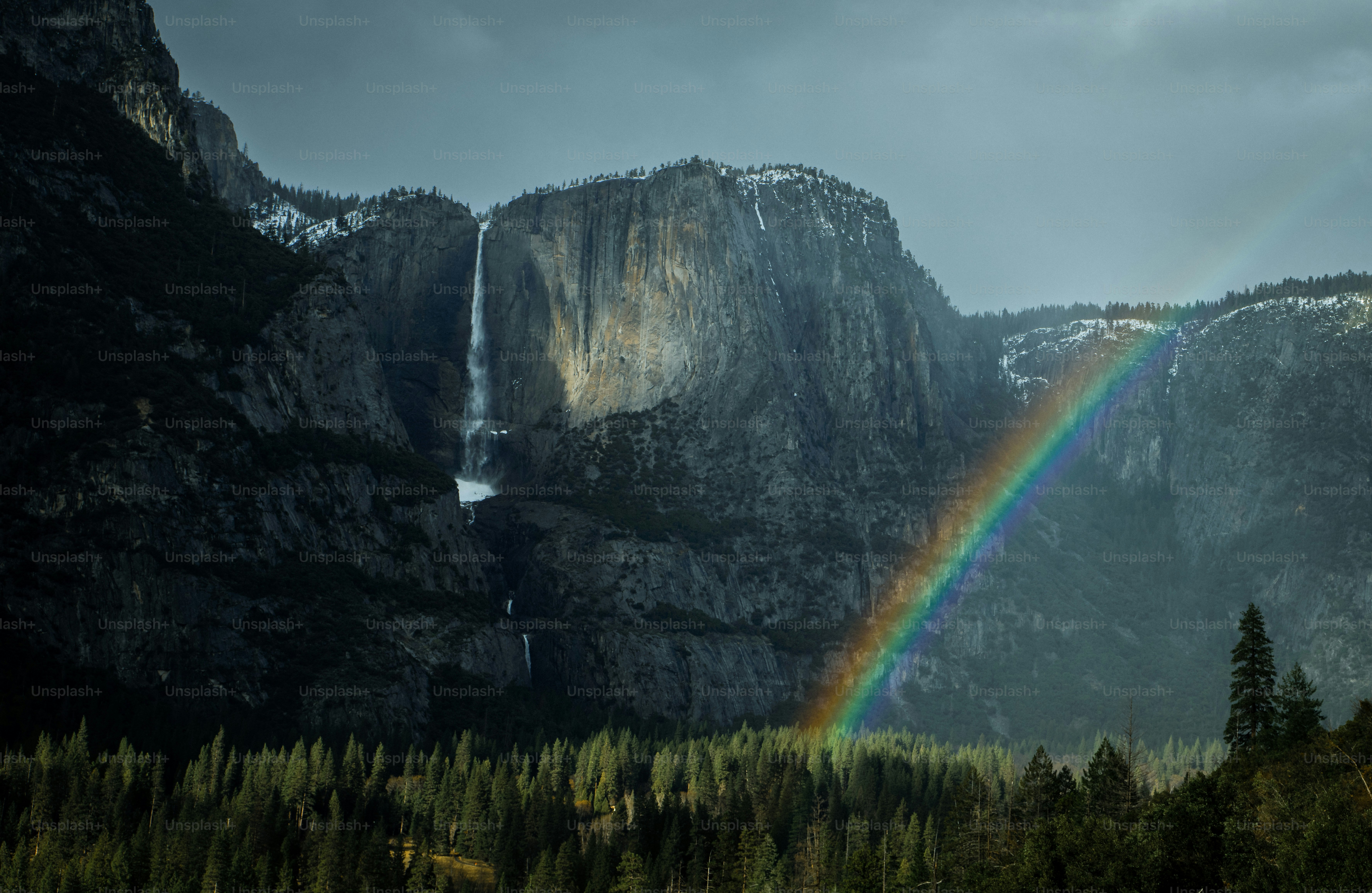 A rainbow in the sky over a waterfall