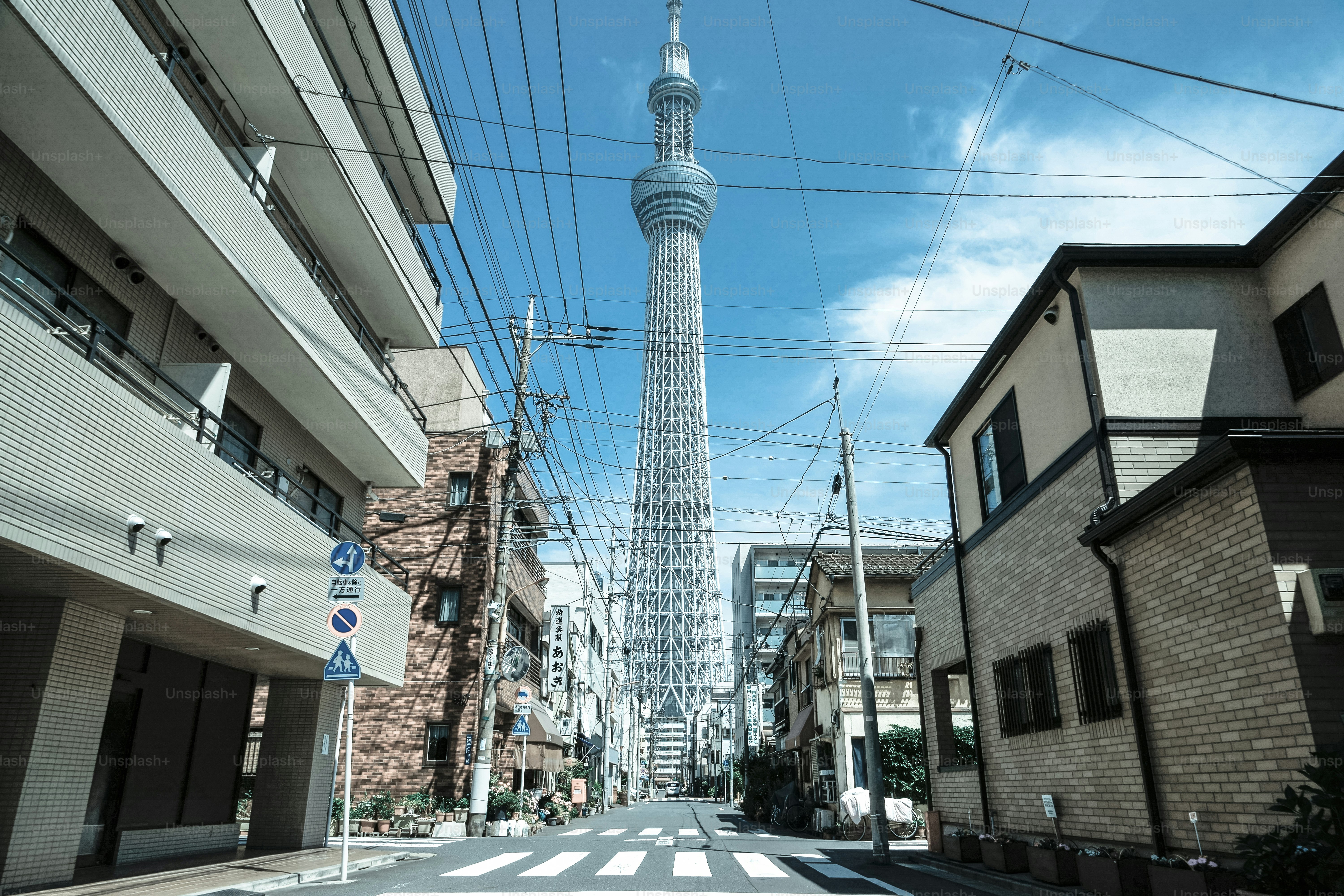 A picture of a street with a very tall tower in the background