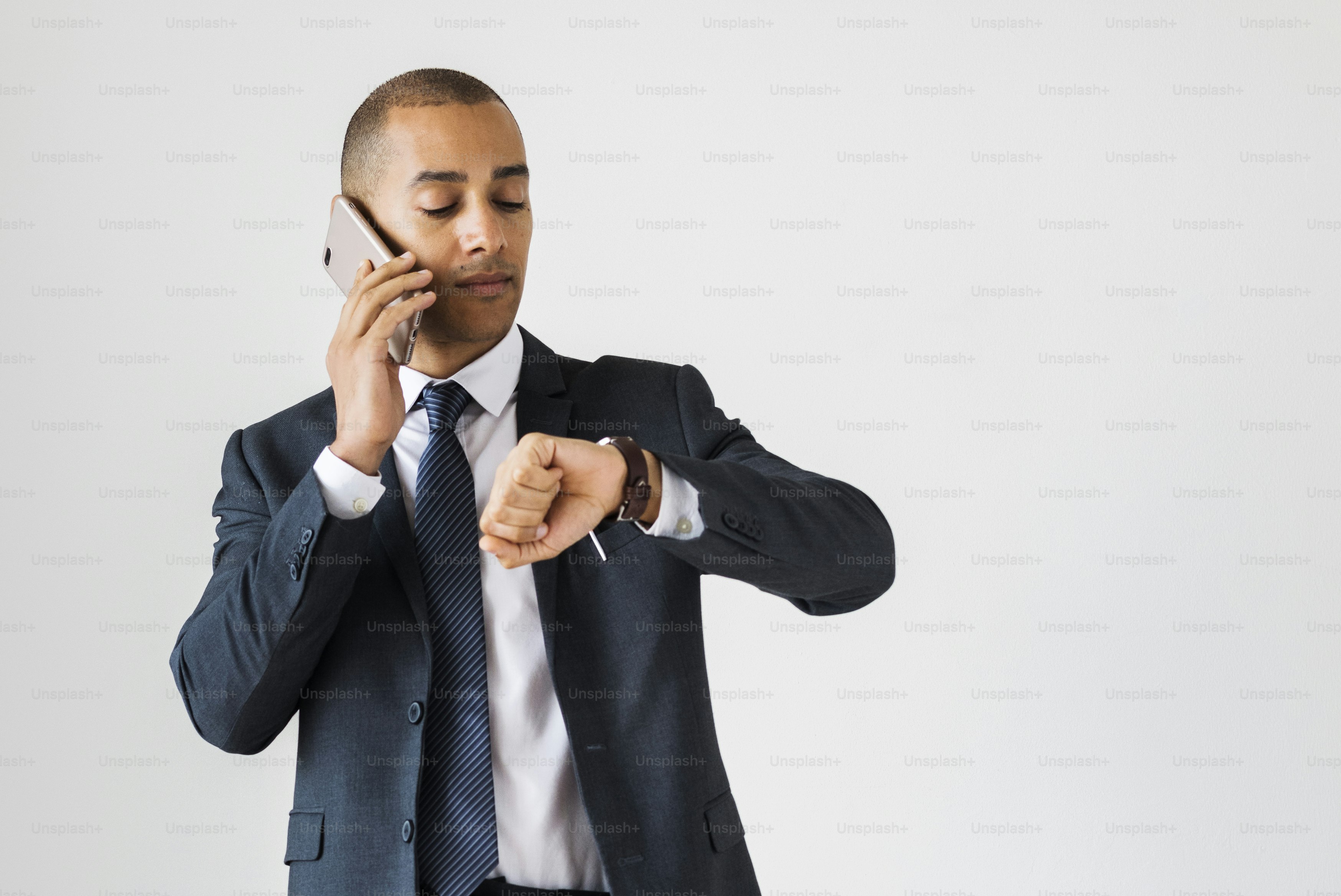 Businessman talking on call checking time fro wrist watch