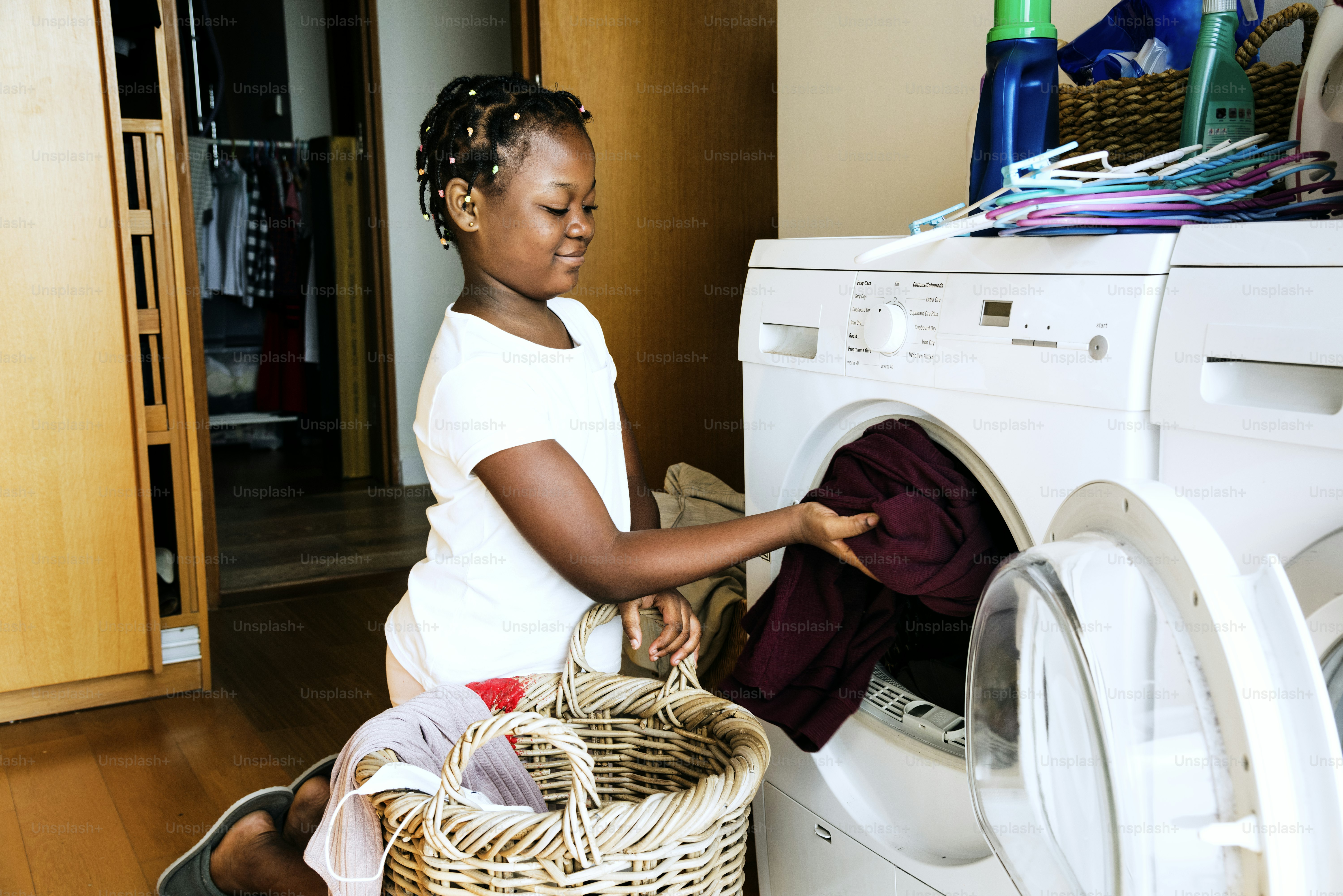 Young teen girl washing clothes using washing machine